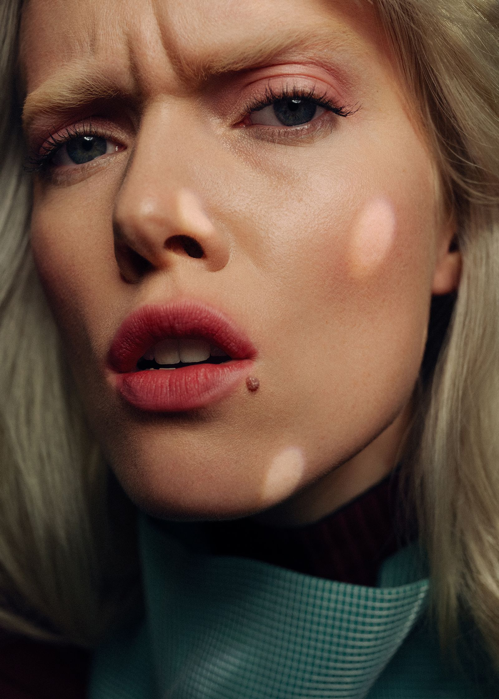 a woman with blond hair and blue eyes is staring at the camera