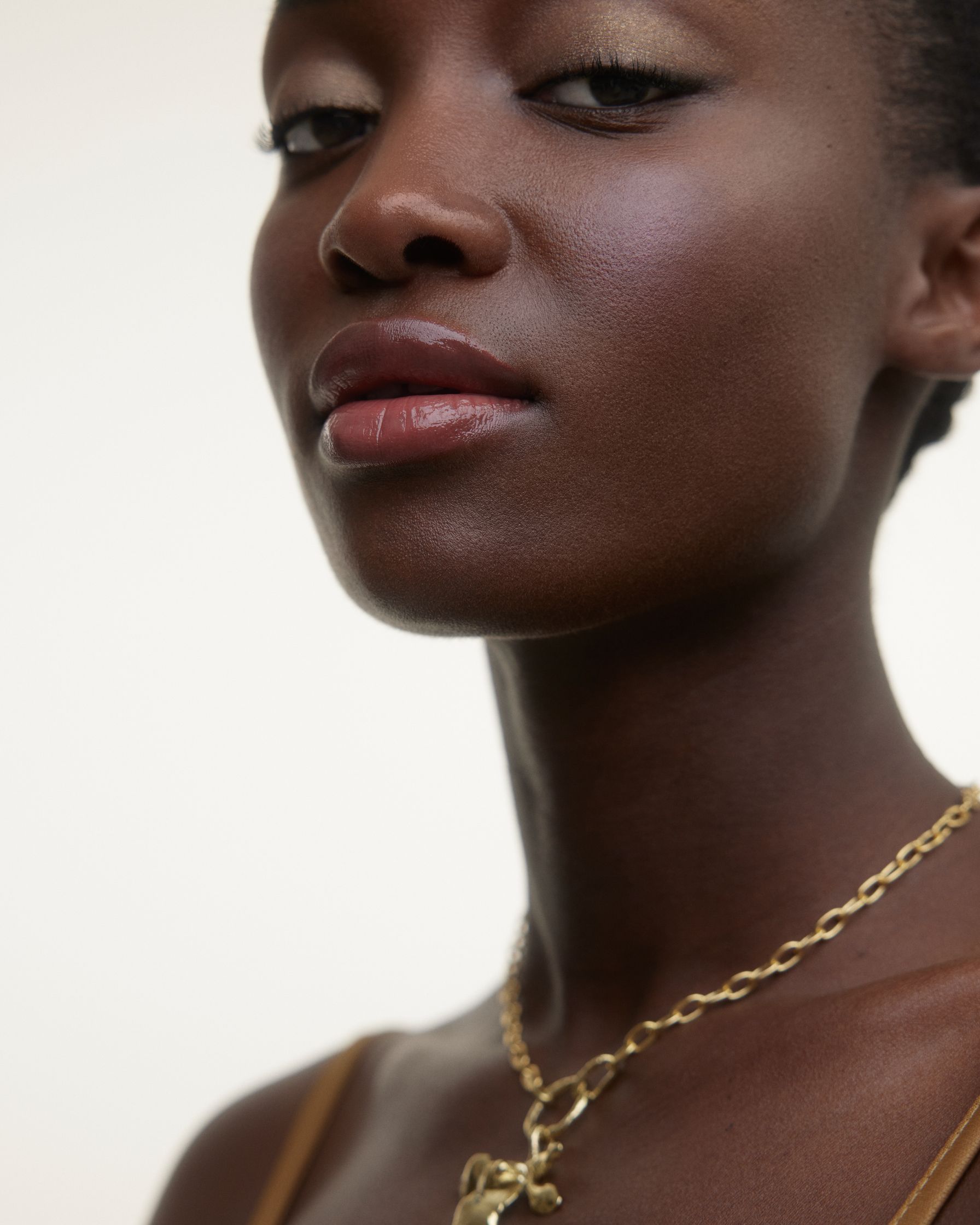 a black woman wearing a gold necklace