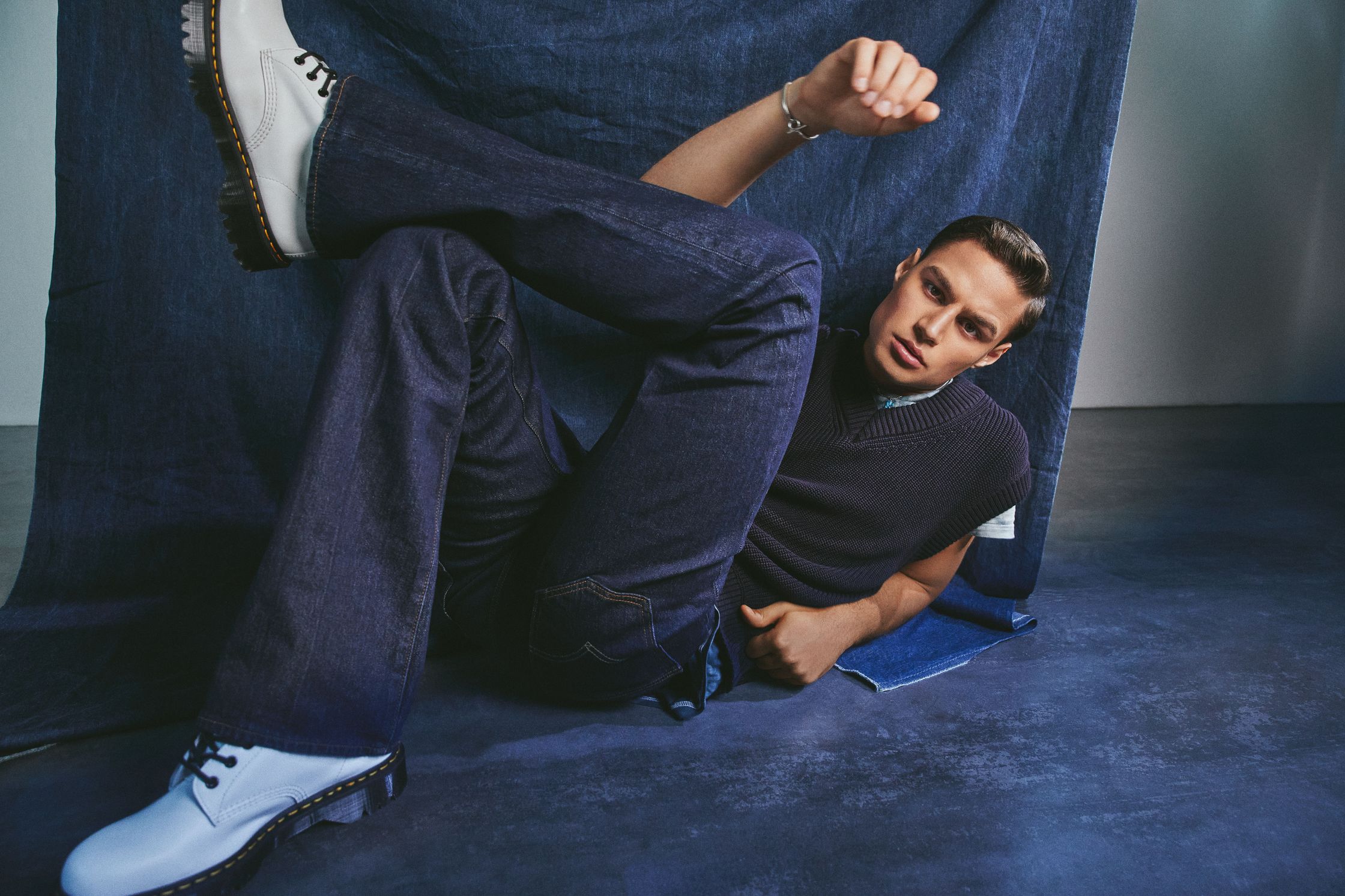 a man laying on the floor in blue jeans