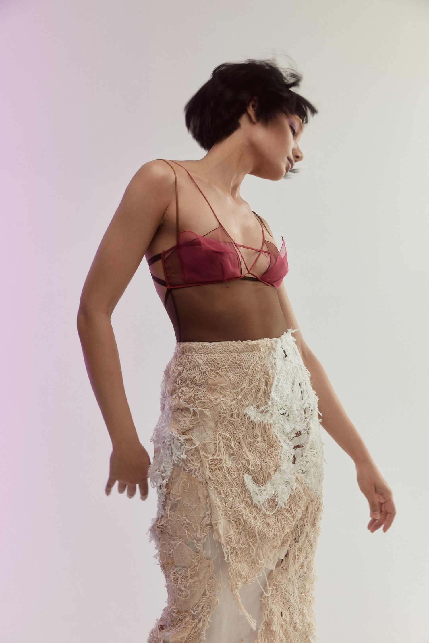 a woman in a sheer skirt posing in front of a white background