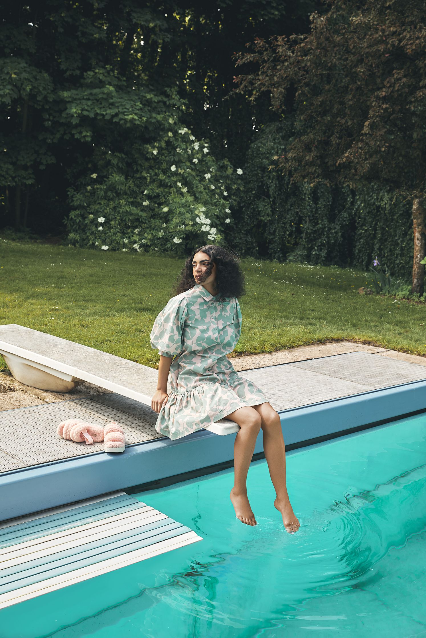 a woman sitting on the edge of a pool
