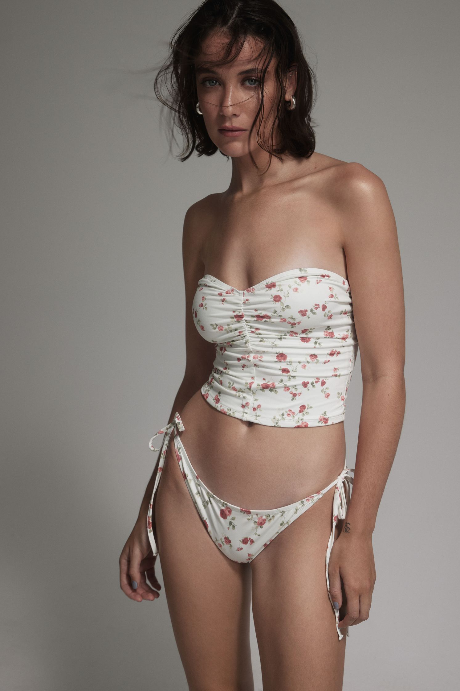 a woman in a white bikini with a floral print