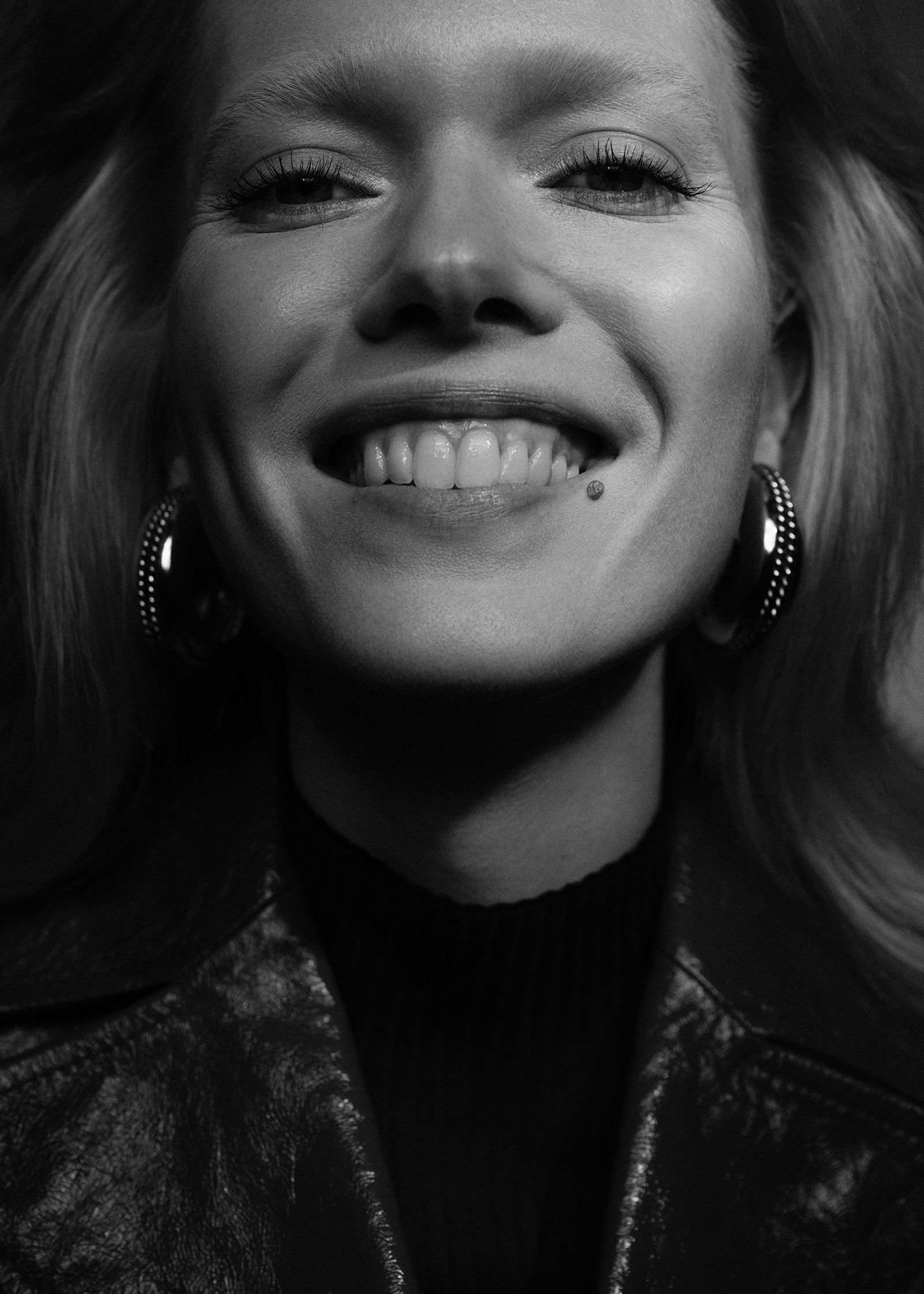 a black and white photo of a woman smiling