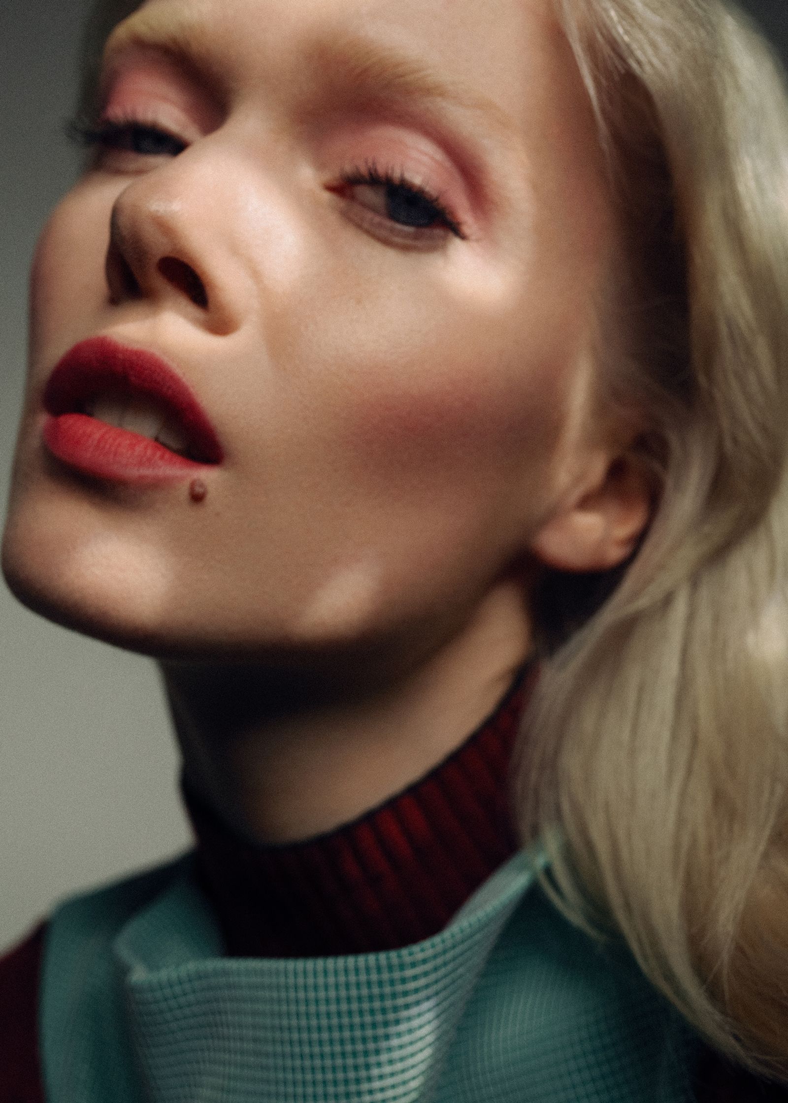 a woman in a turtle neck with red lipstick