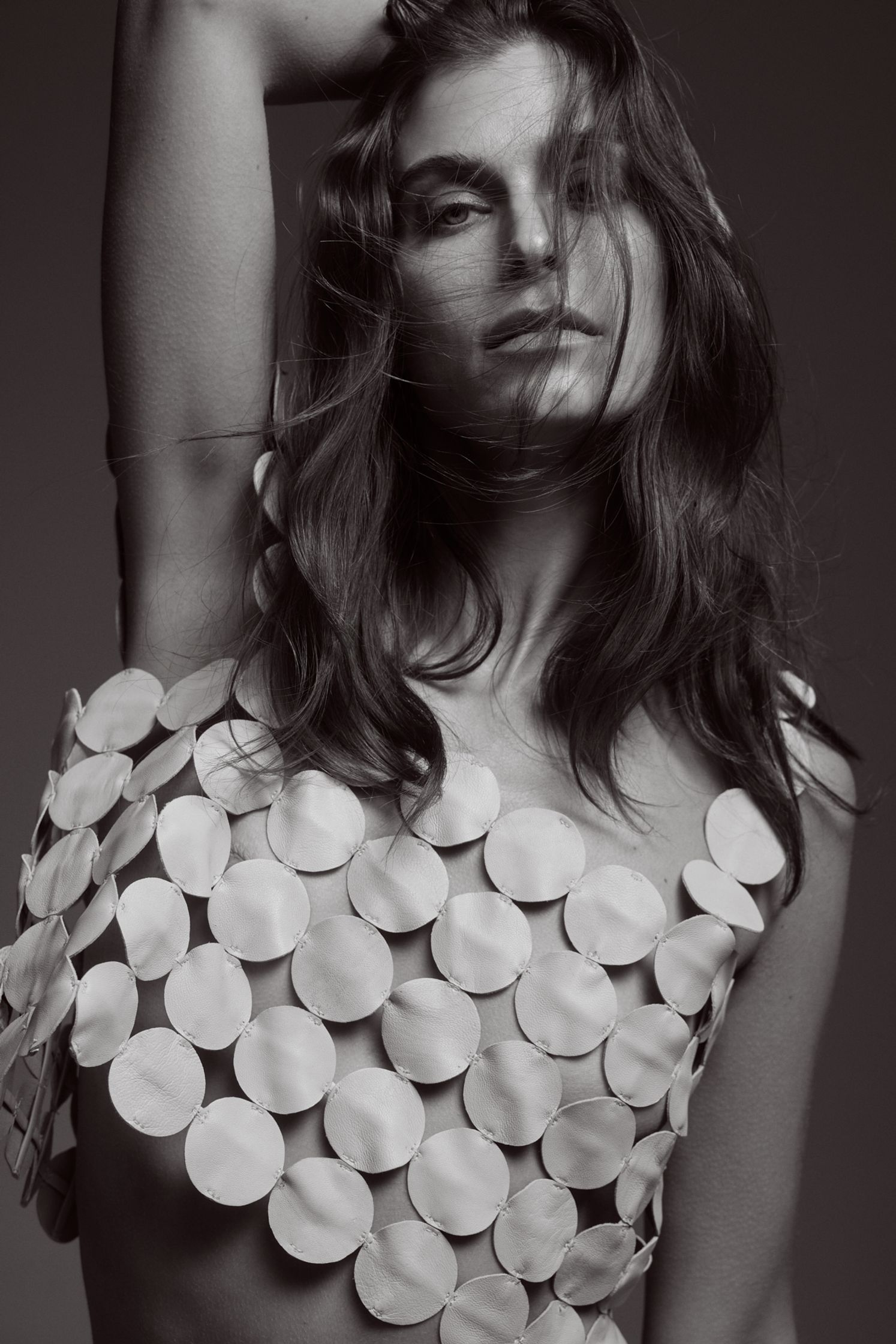 a black and white photo of a woman posing in a white top