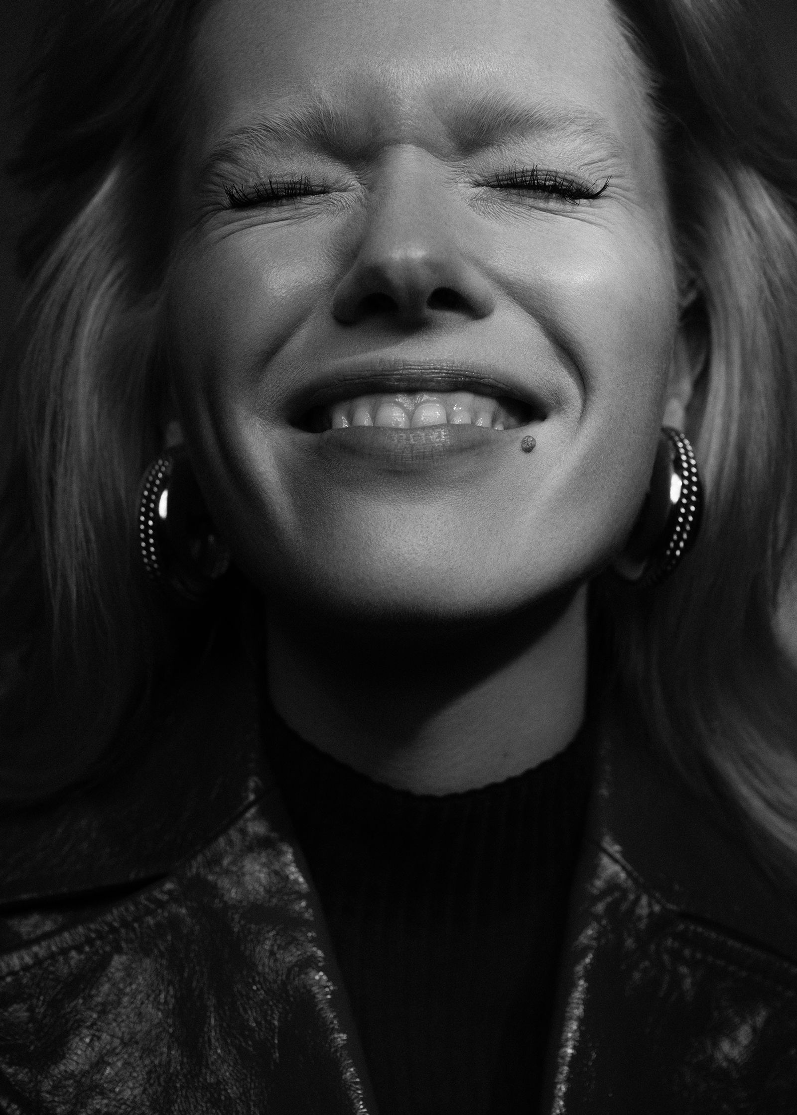 a black and white photo of a woman smiling