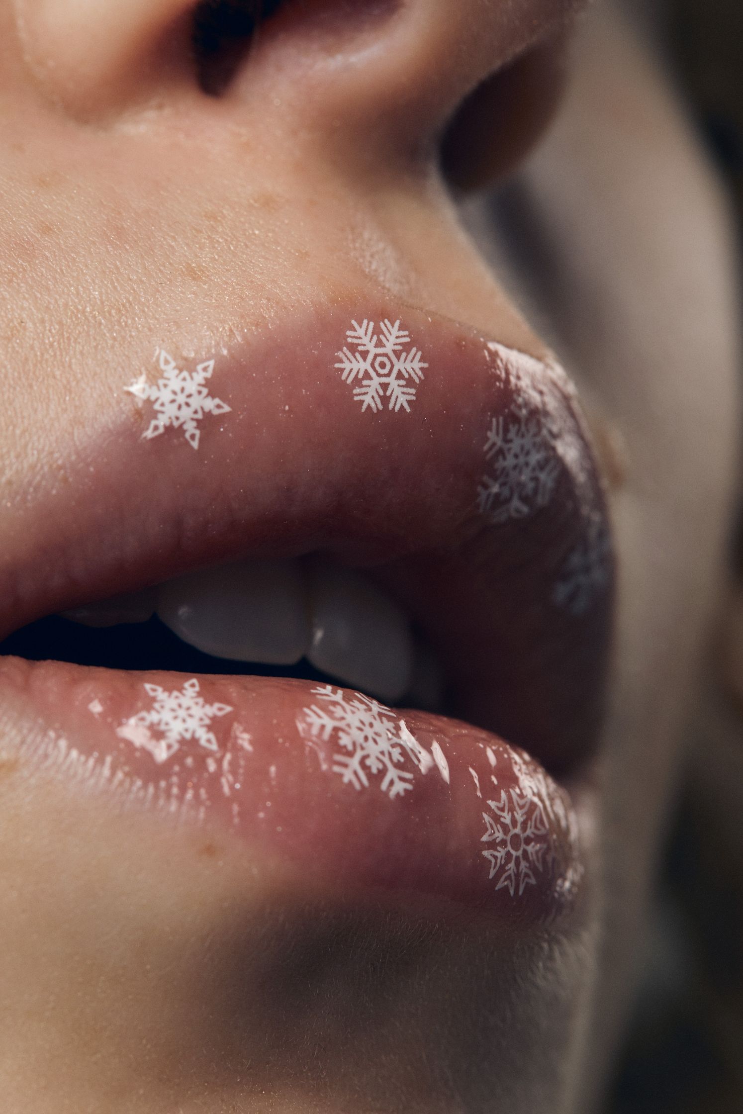 a close up of a woman's lips with snowflakes on them