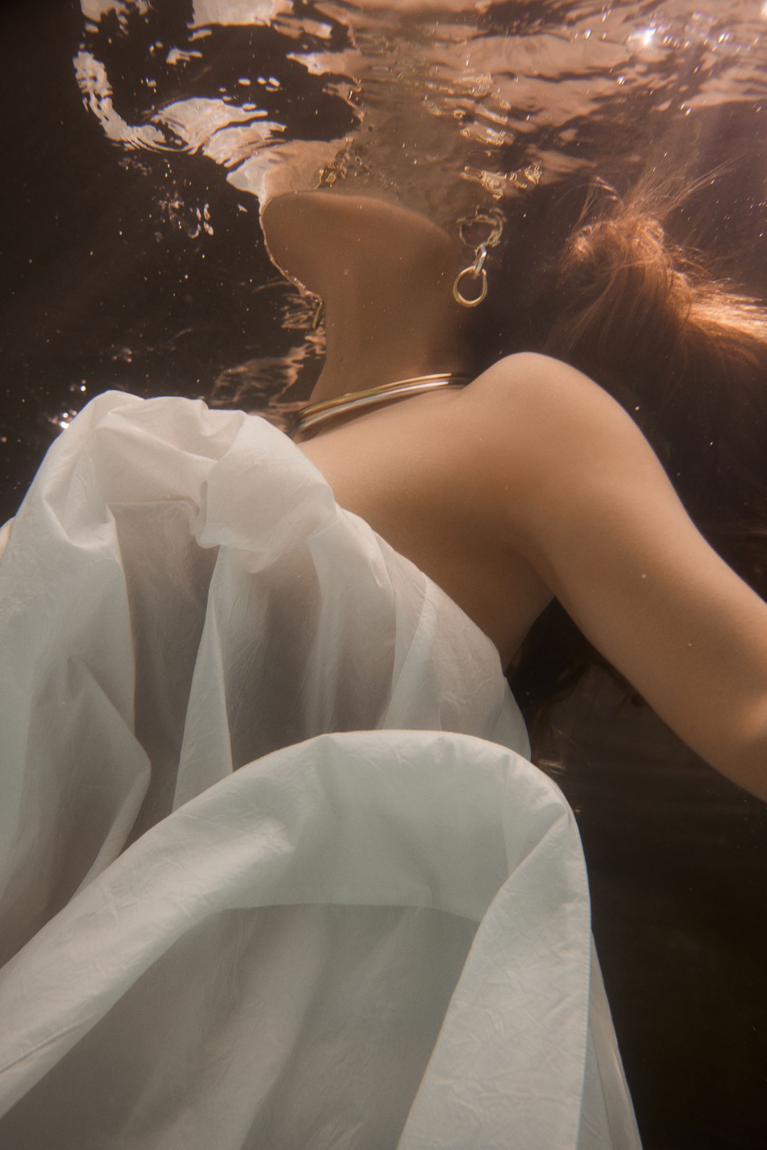 a woman underwater in a white dress