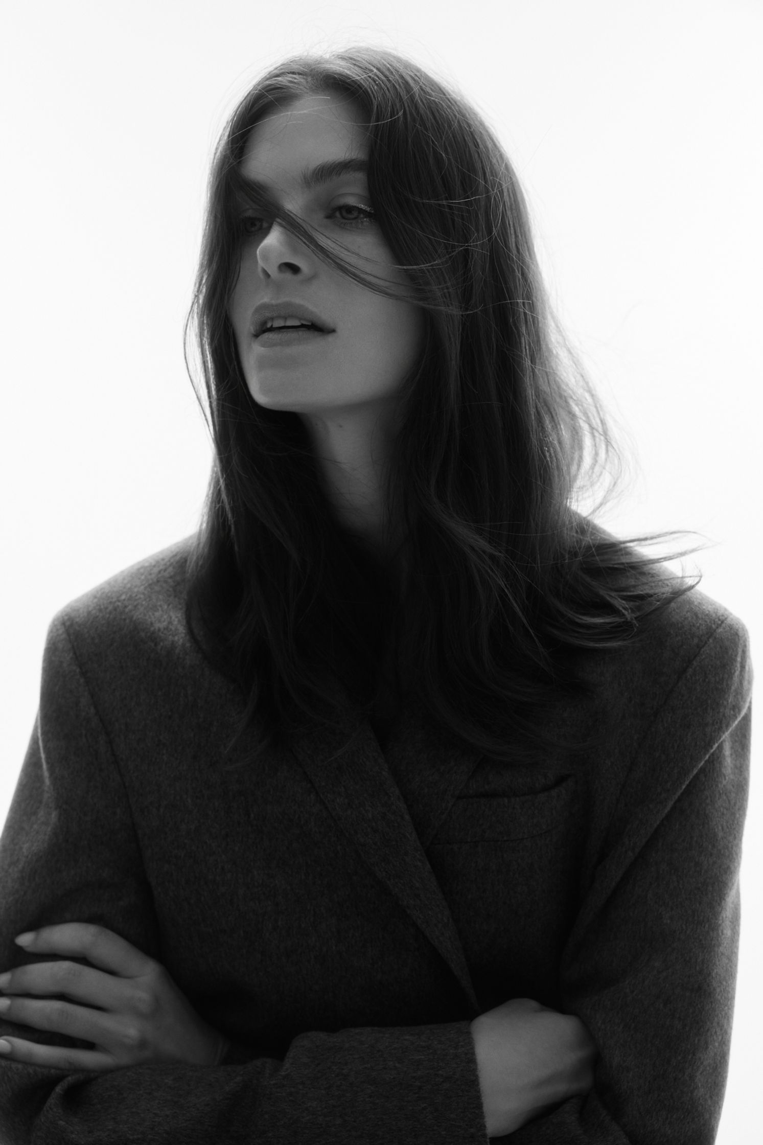 a black and white photo of a woman in a coat