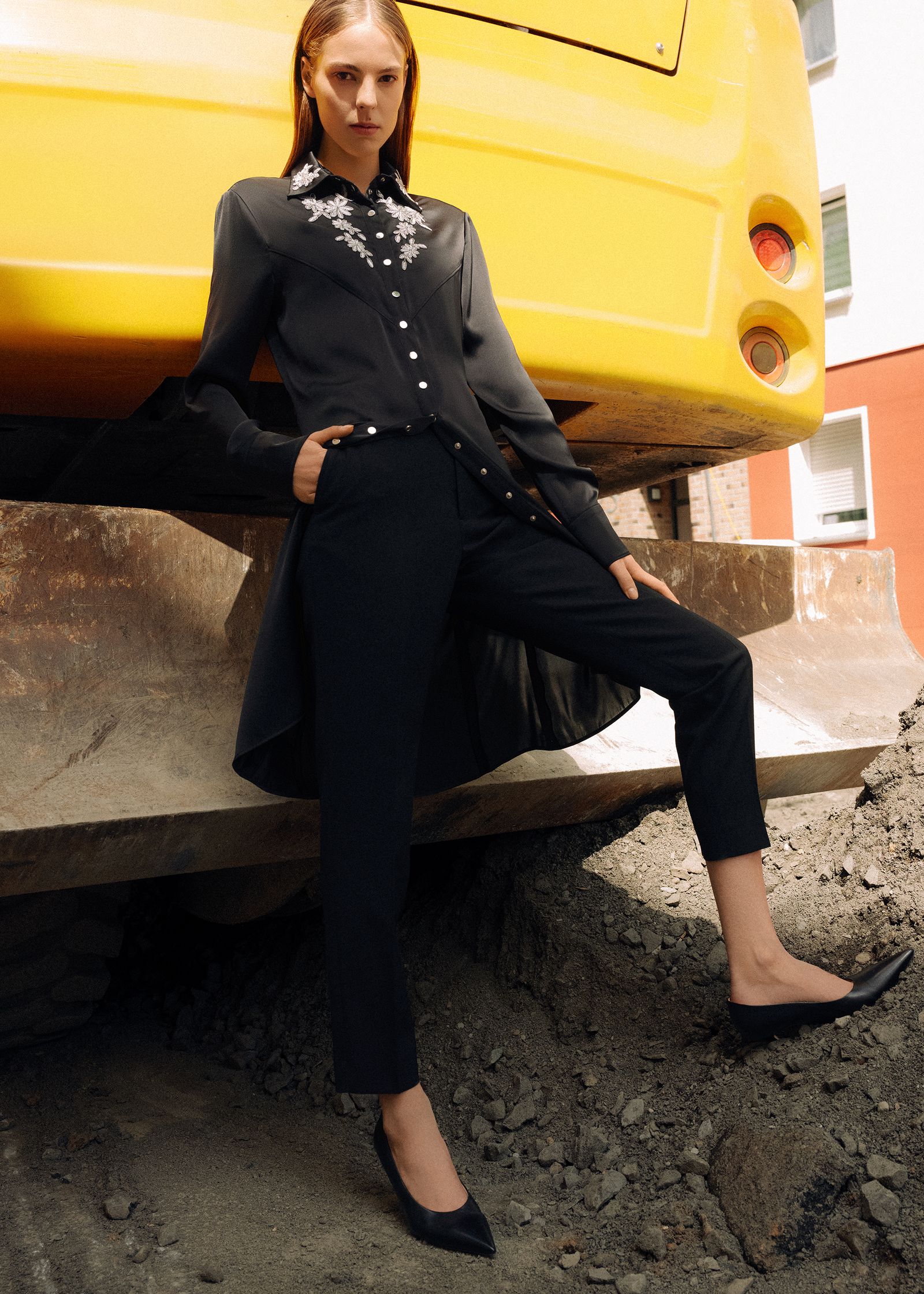 a woman is leaning against a yellow bus