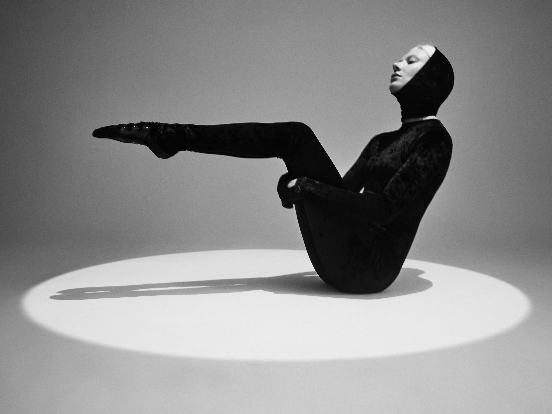a black and white photo of a woman in a black outfit
