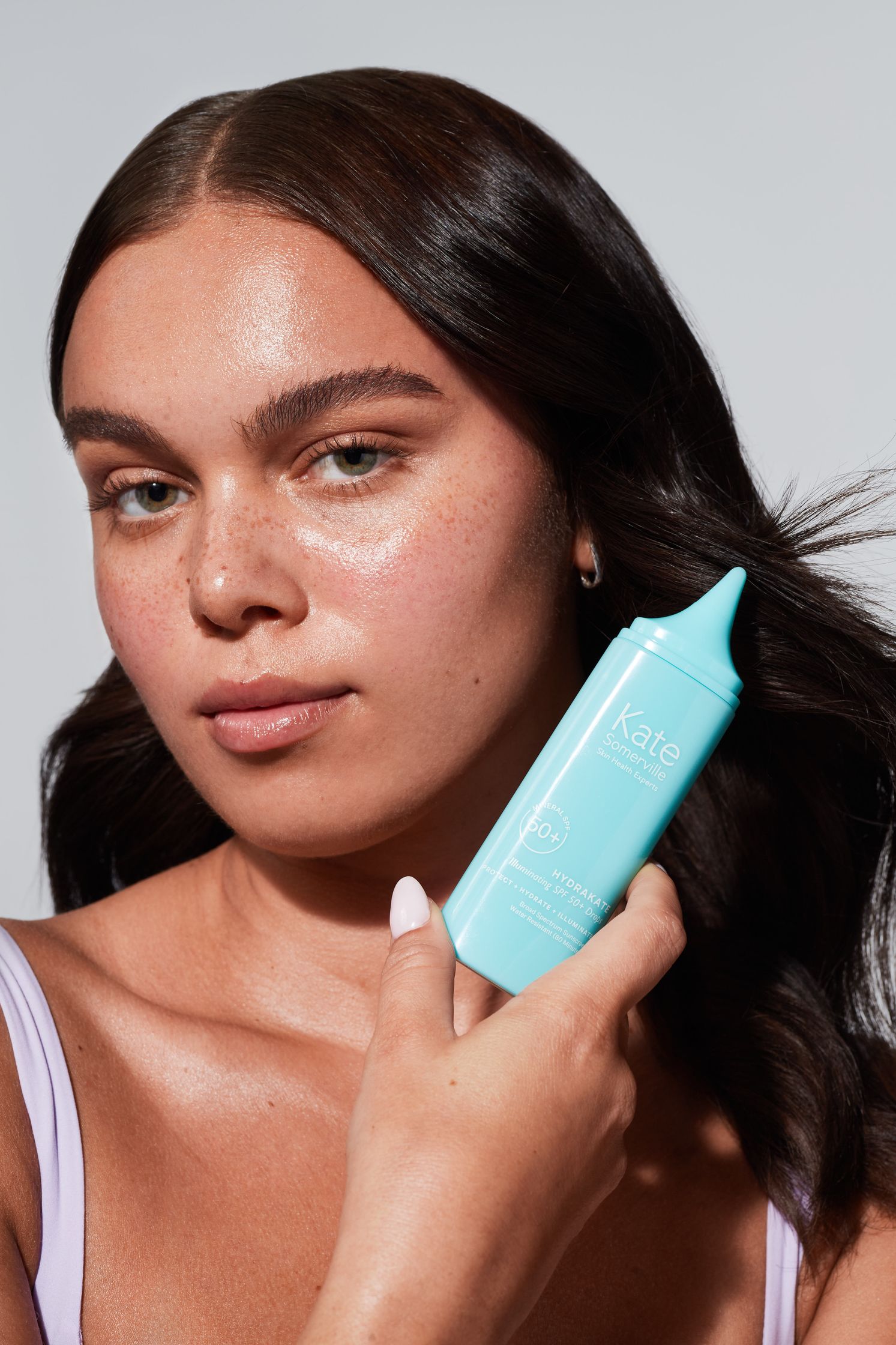 a woman holding a blue bottle of lotion