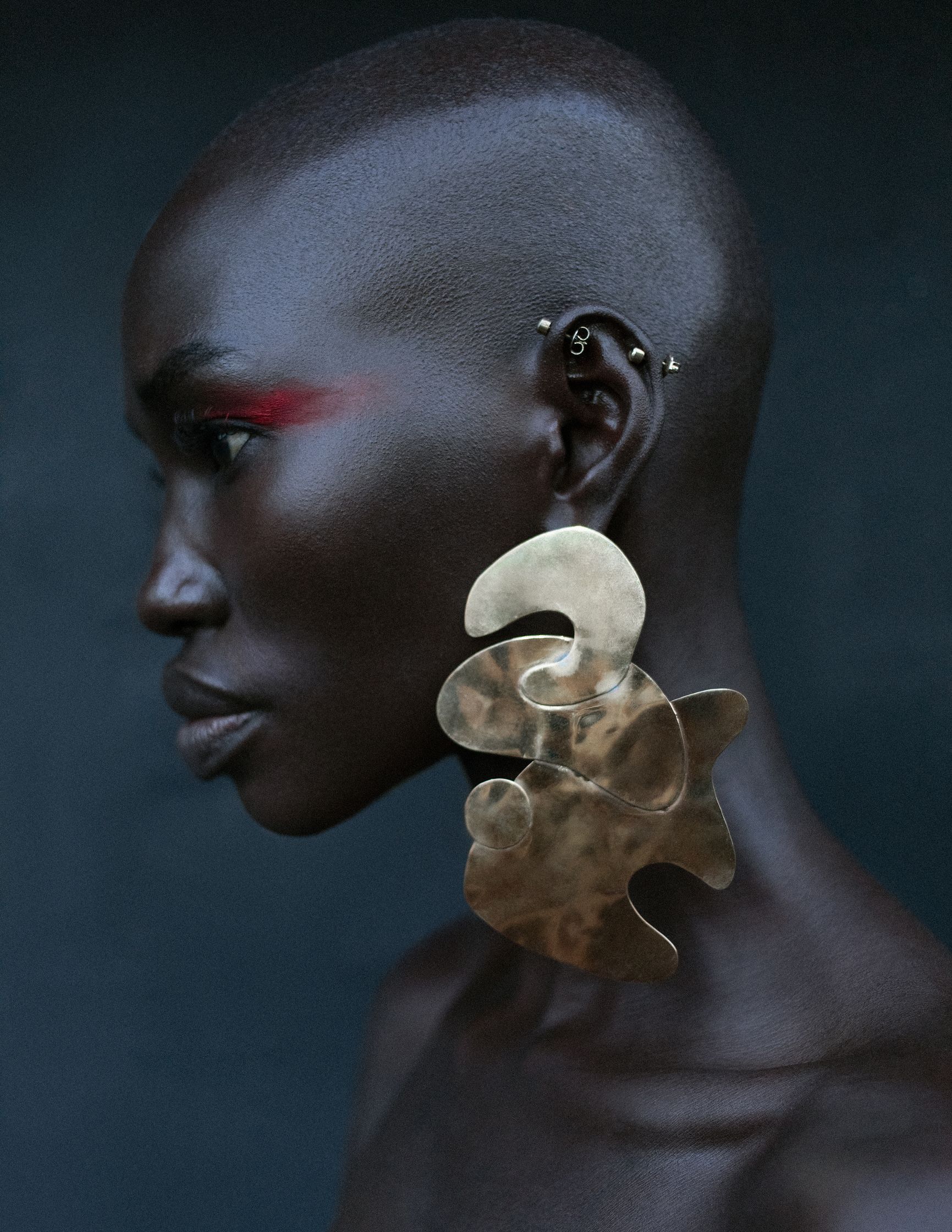 a woman with a shaved head and pierced ears