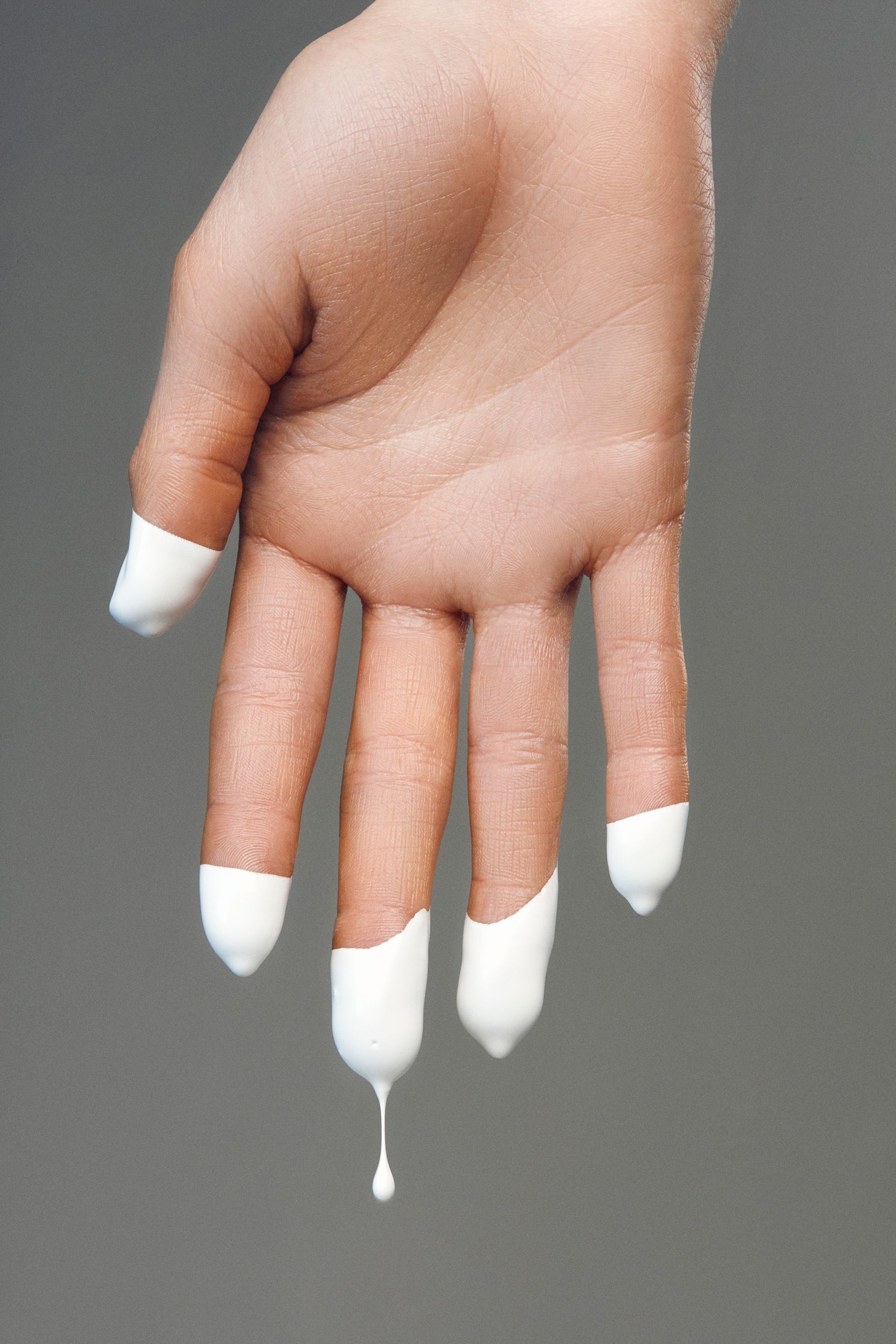 a hand with white nail polish on it