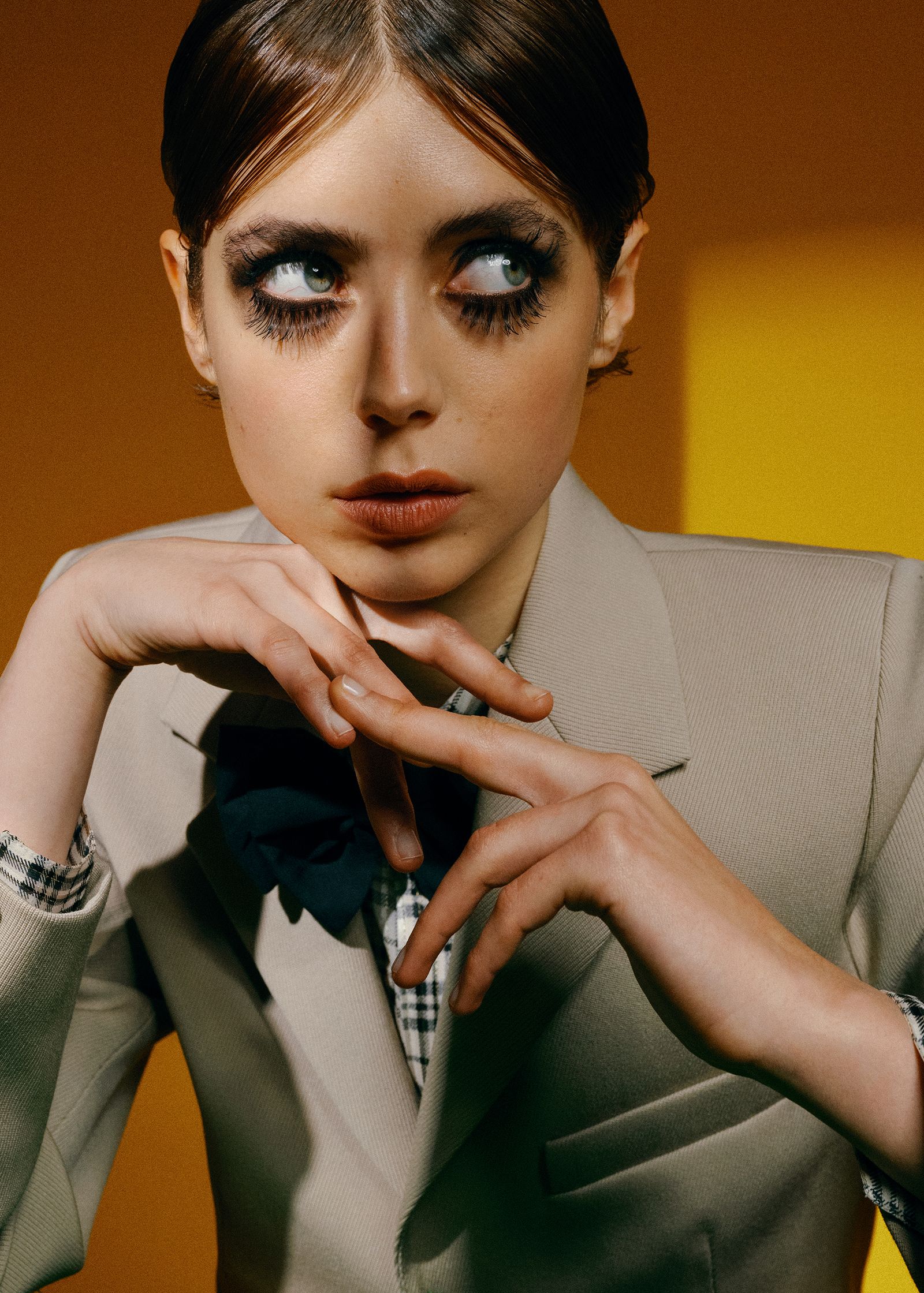 a woman is posing with her hands on her face