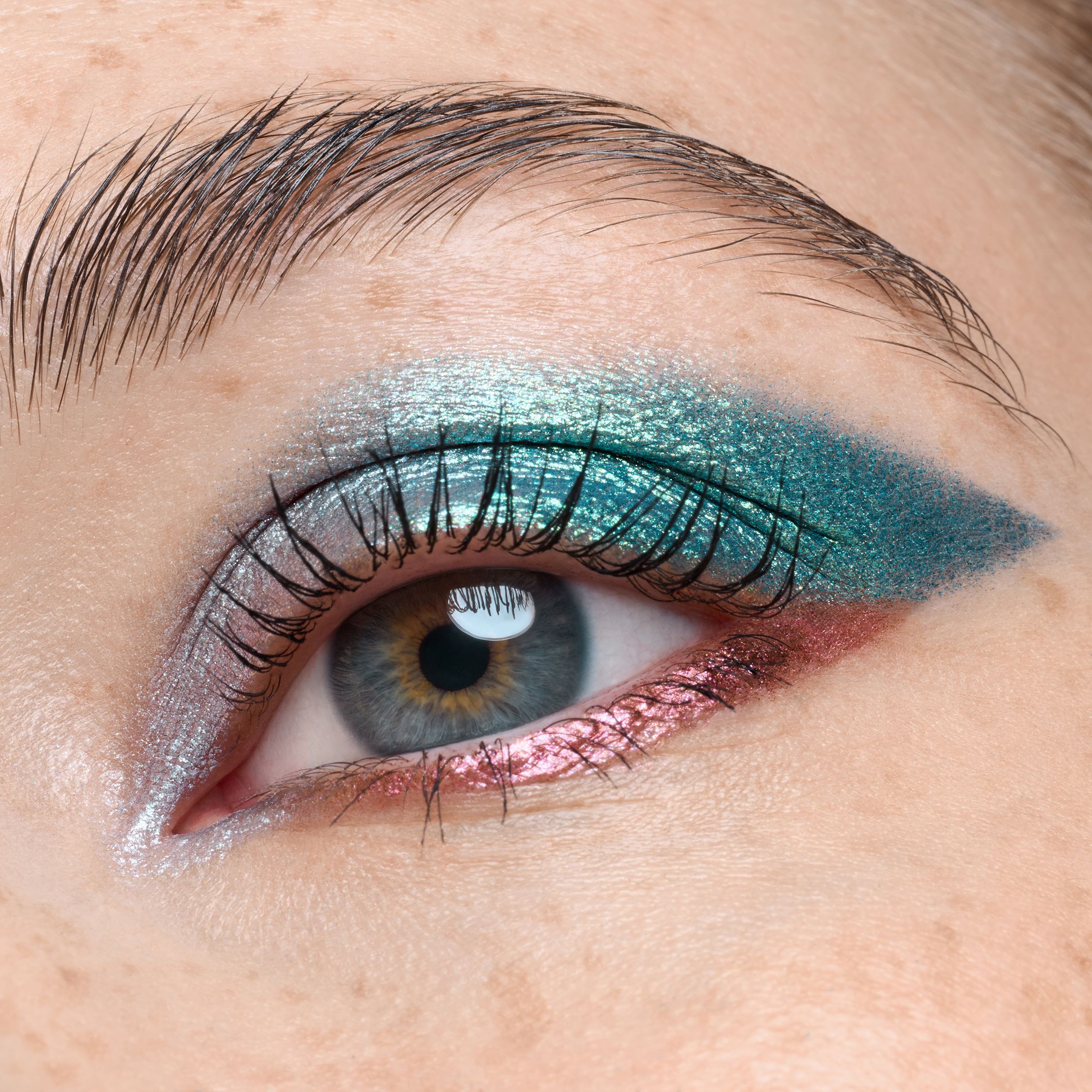 a close up of a woman's eye with a blue and pink eyeshadow
