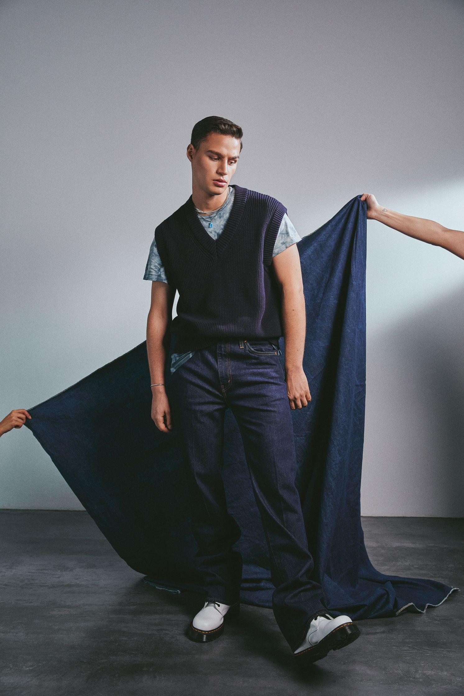 a man and a woman standing next to a large piece of fabric