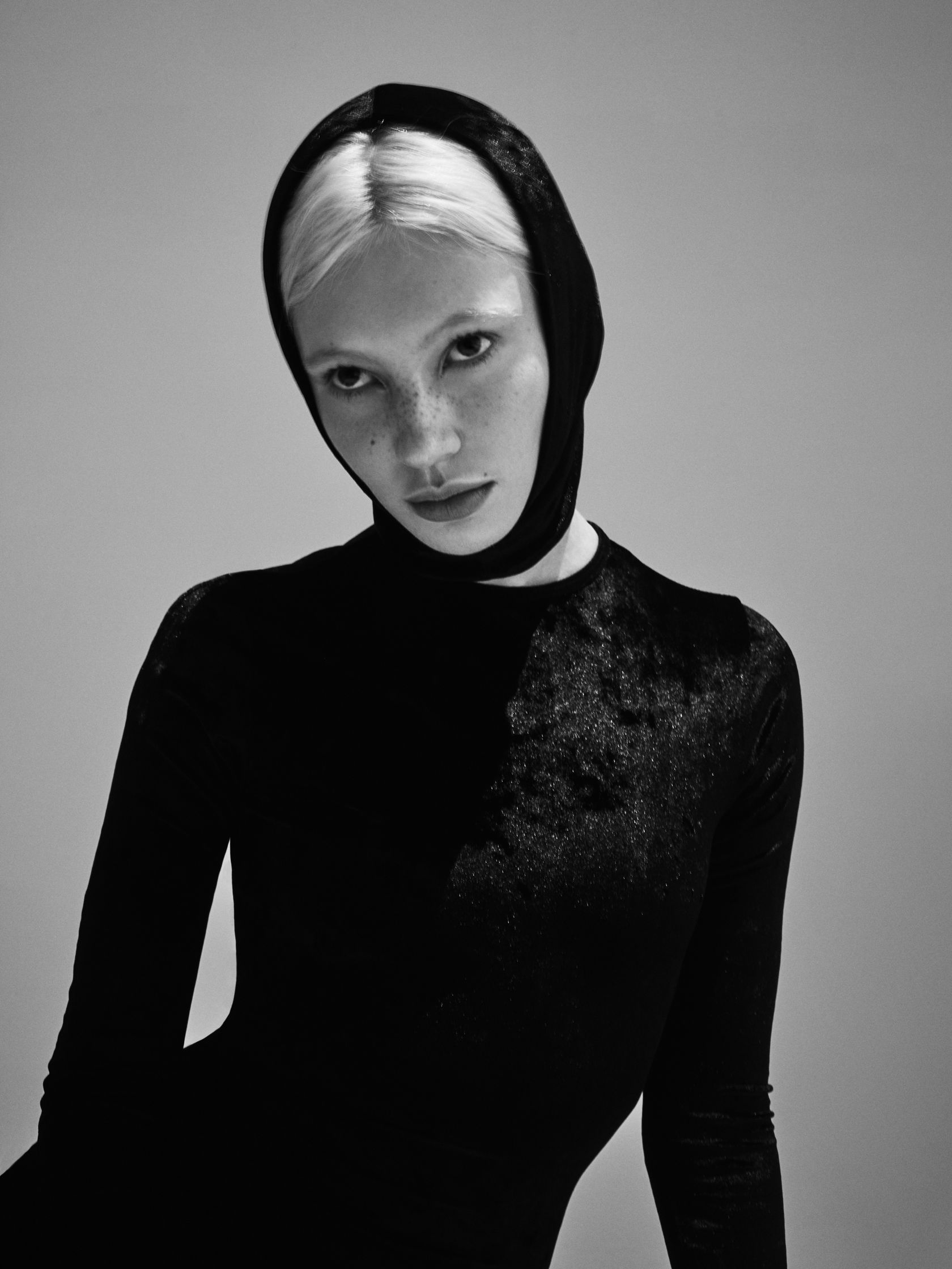 a black and white photo of a woman in a black dress