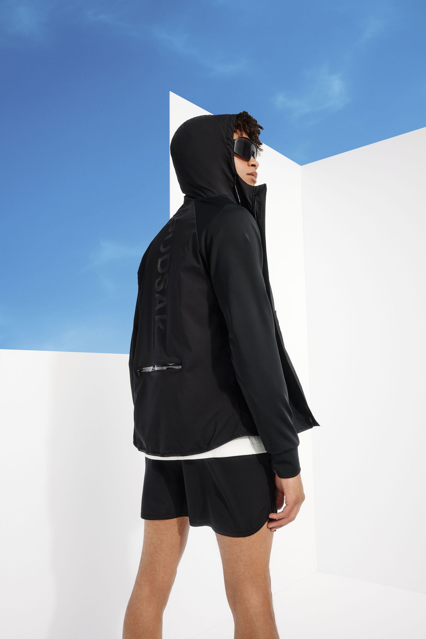 a man wearing a black hoodie and shorts