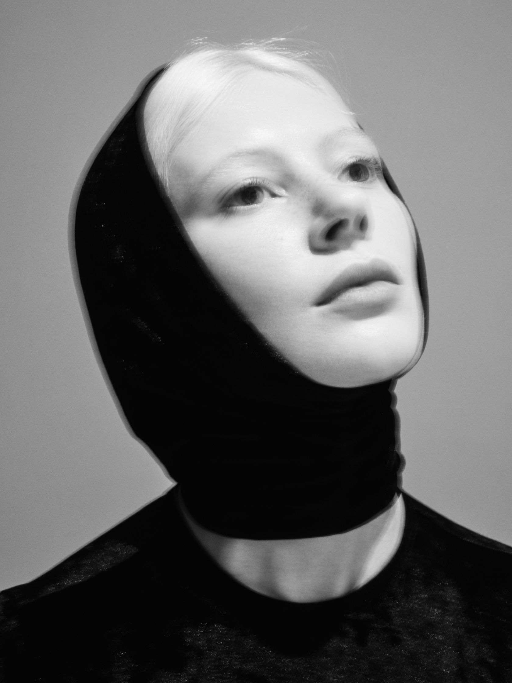 a black and white photo of a woman with a head scarf