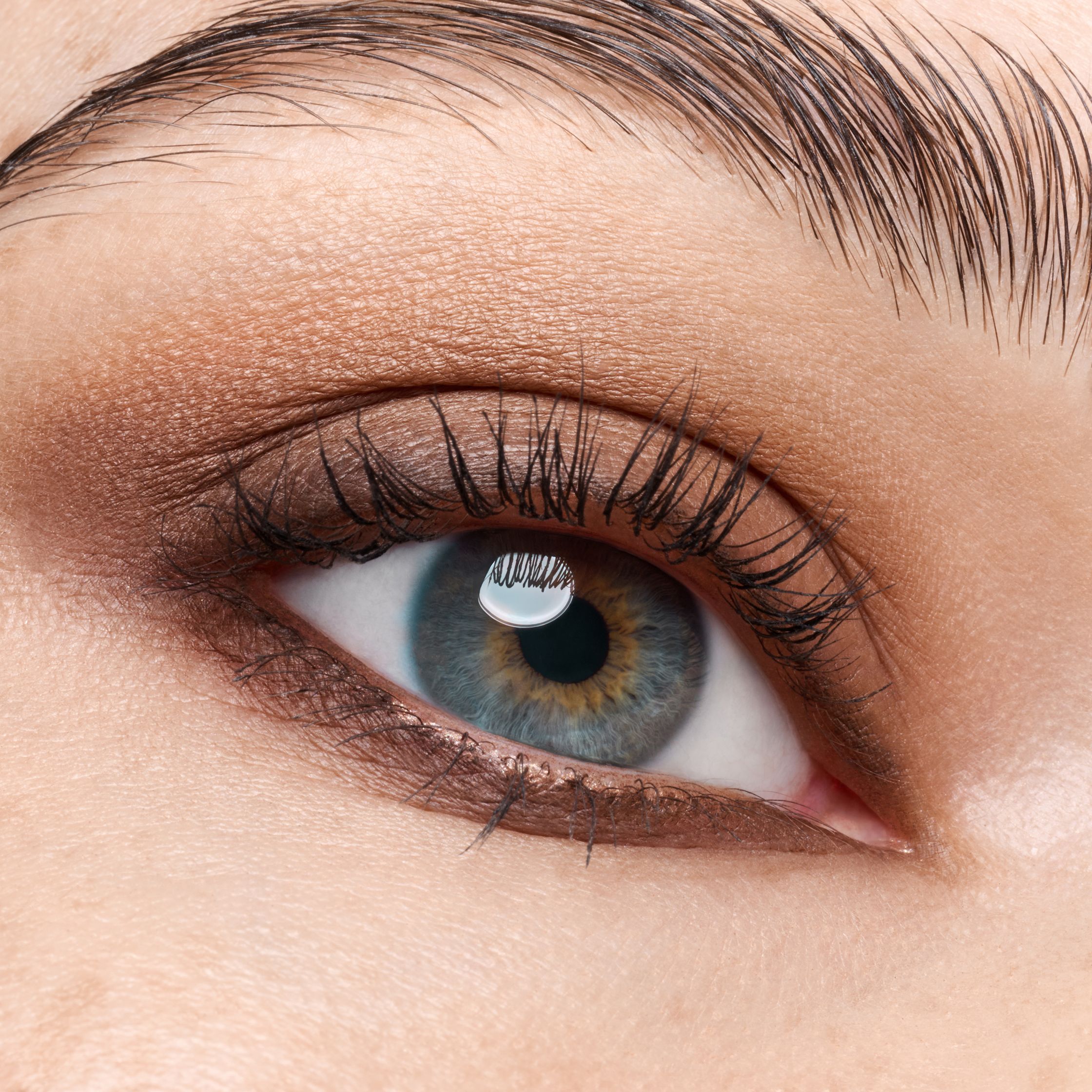 a close up of a woman's eye with brown eyelashes