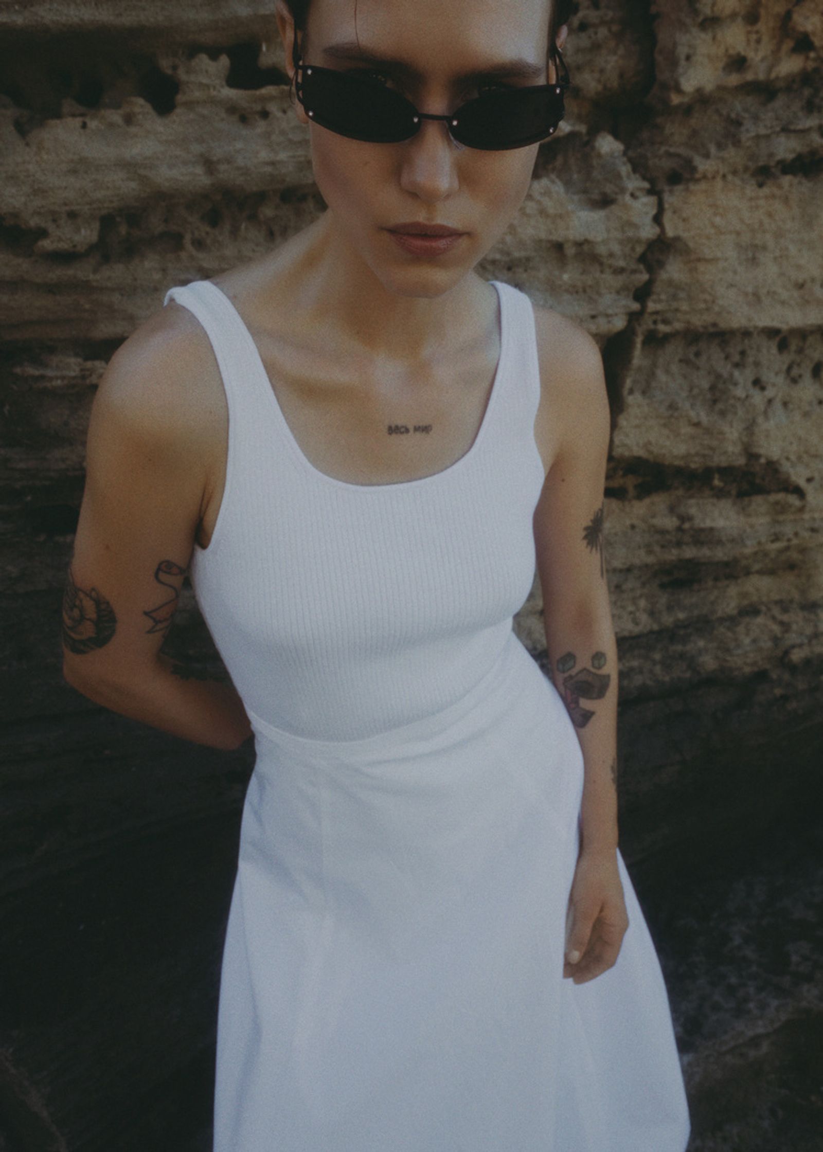 a woman wearing sunglasses and a white dress