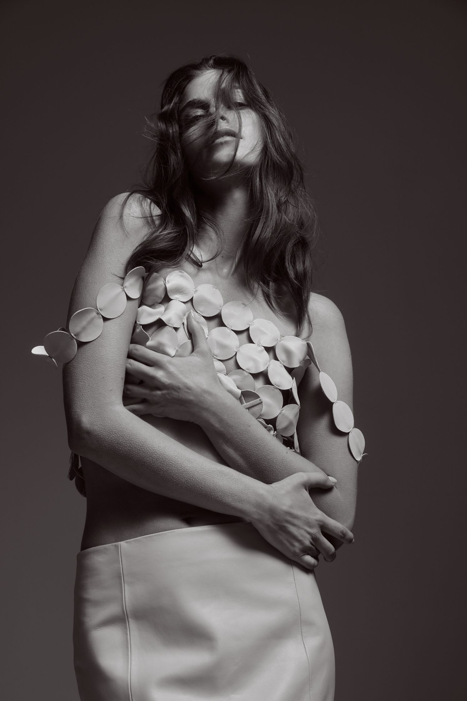 a black and white photo of a woman posing in a white skirt