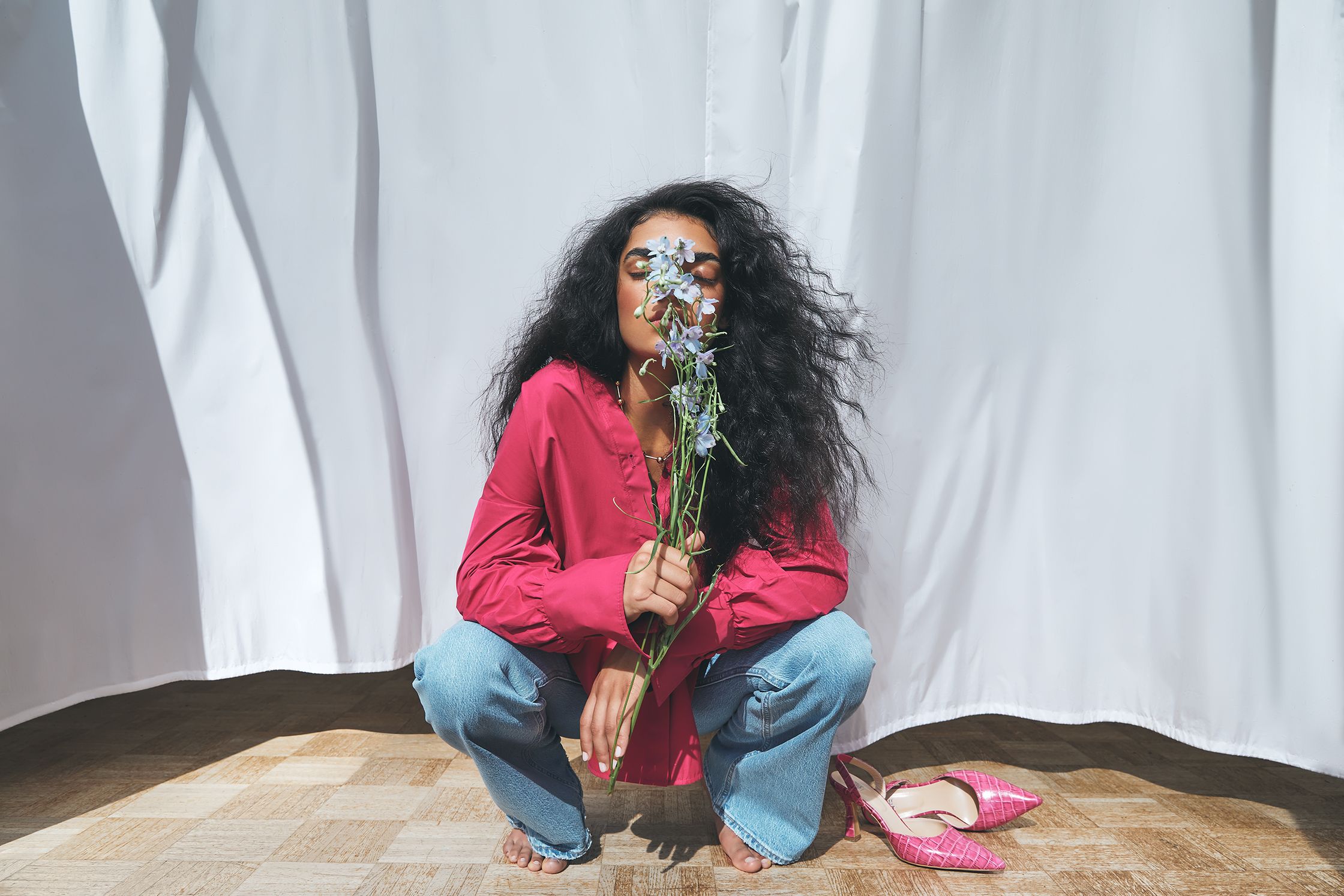 a woman crouching down with flowers in her hands
