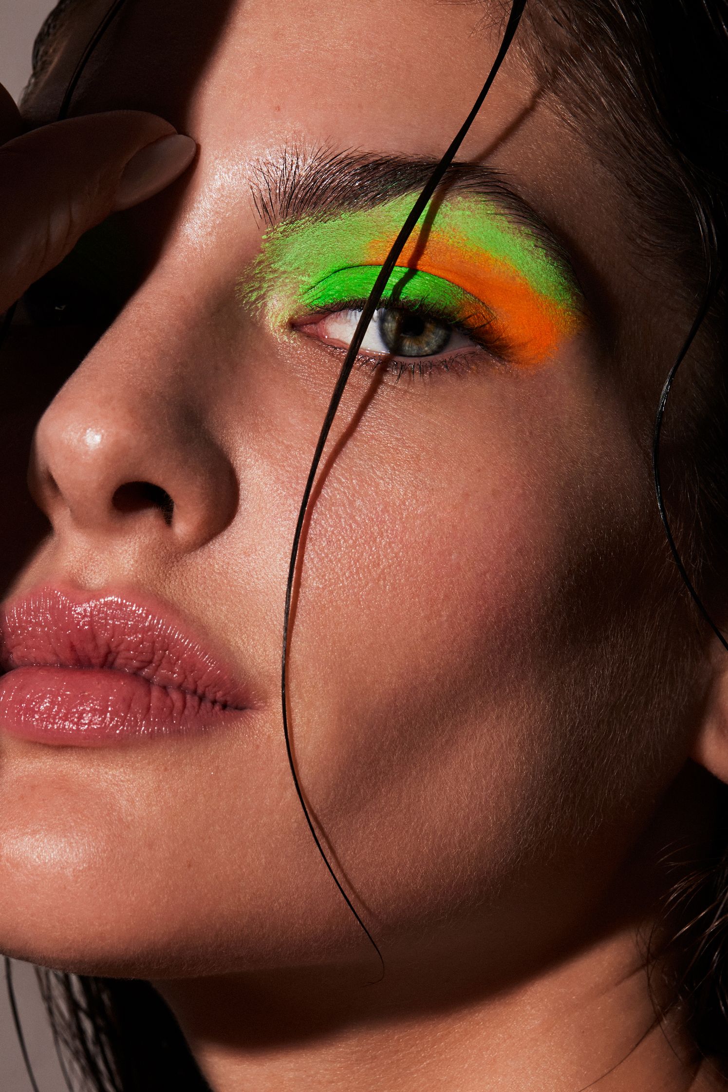 a woman with green and orange eye makeup