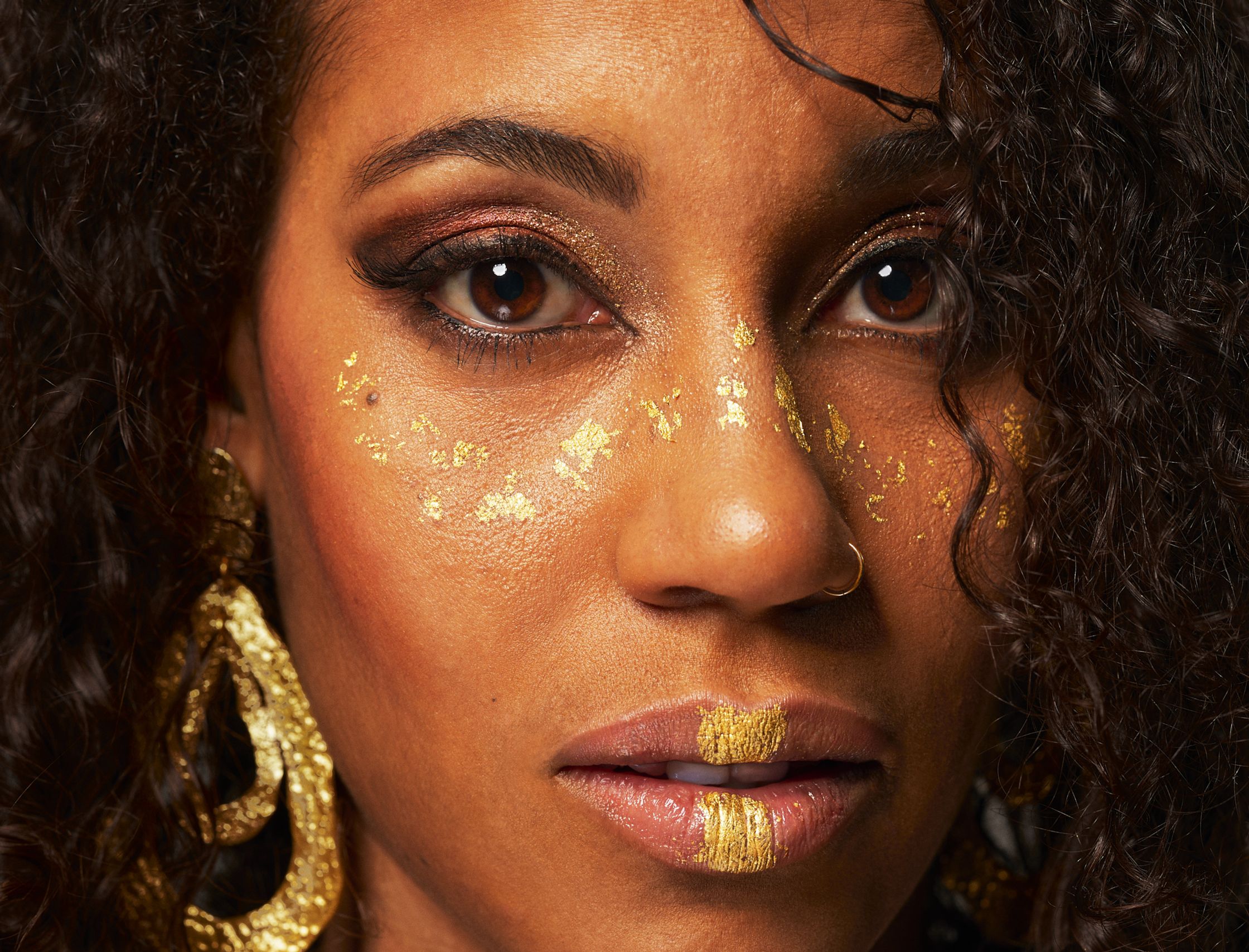 a woman with gold paint on her face