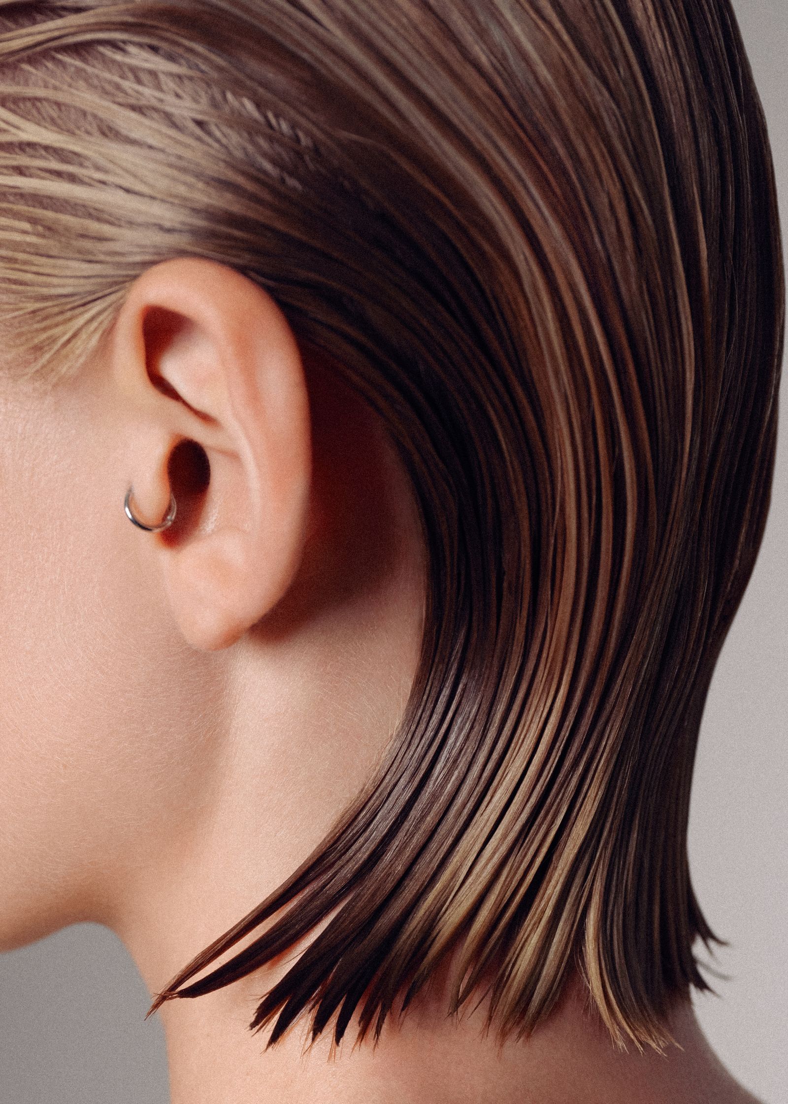 a woman's hair with a piercing in it