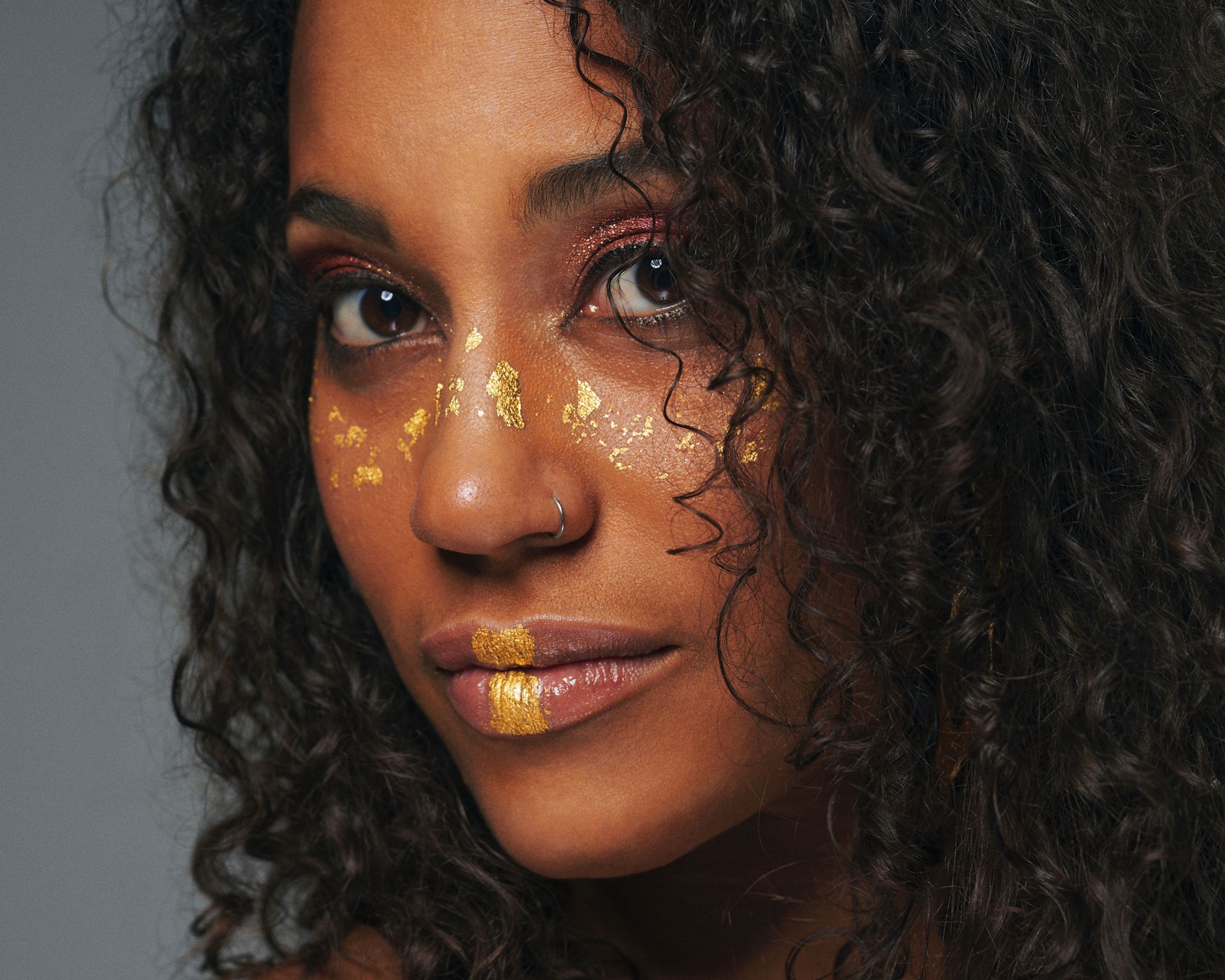 a woman with gold paint on her face