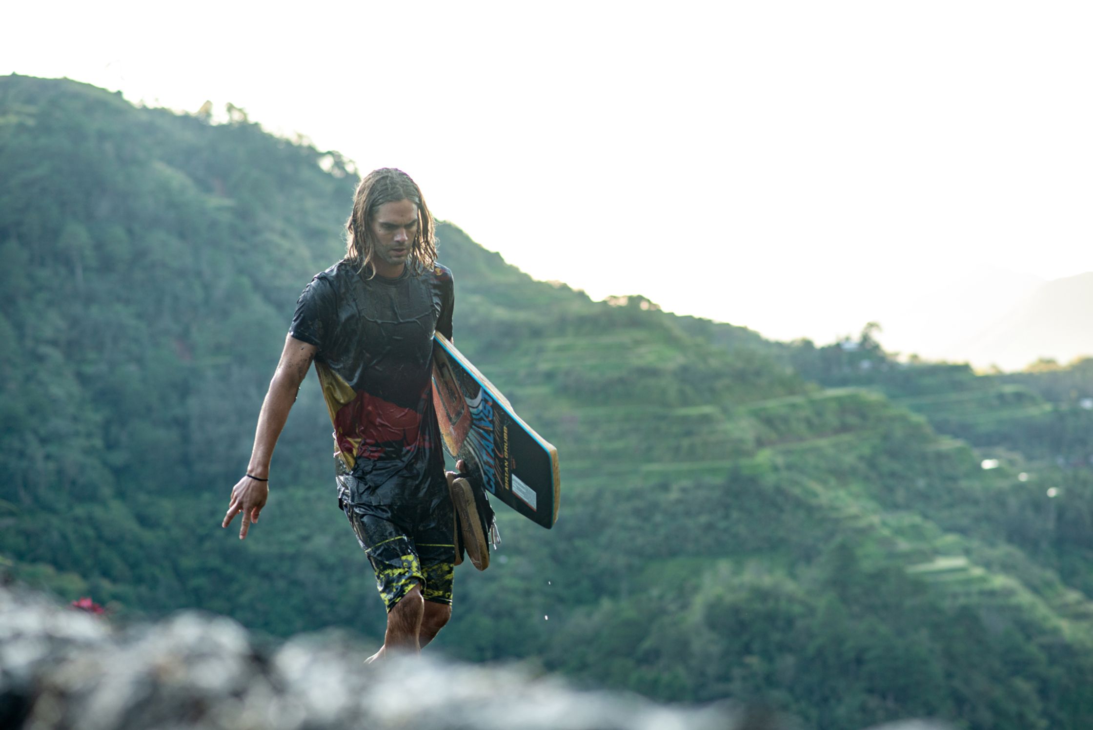 red bull athlete Brian grubb with a wake skate walking down a mountain