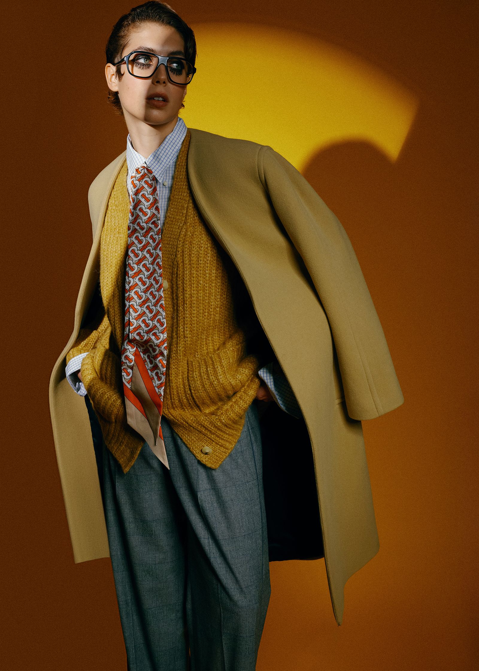 a young man in a yellow coat and tie posing for a photo