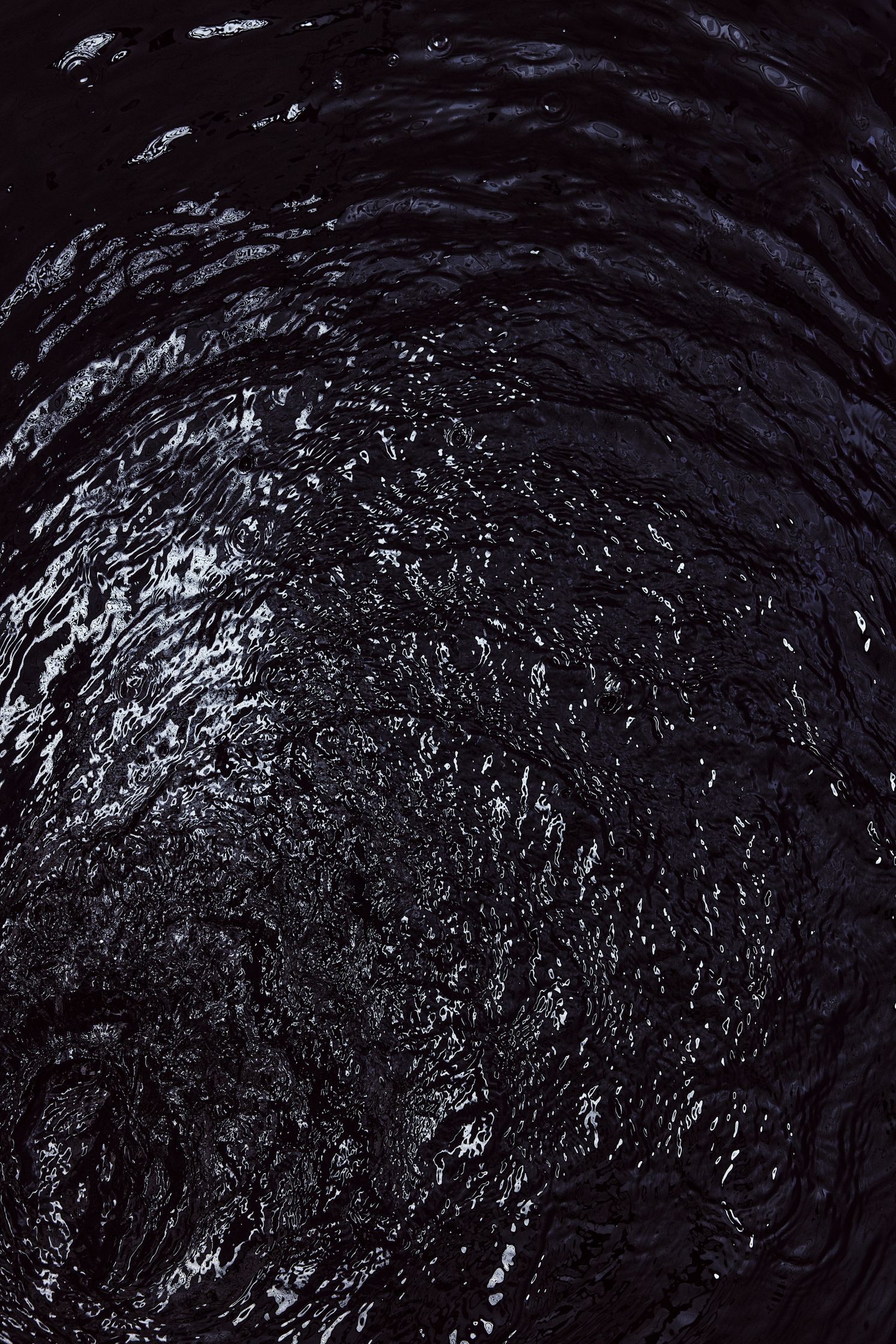 a black and white image of a swirling water