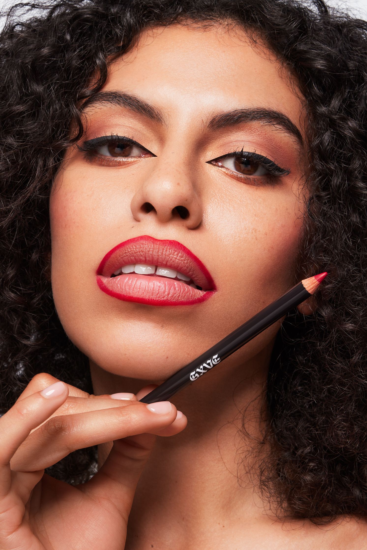 a woman with curly hair holding a red pencil