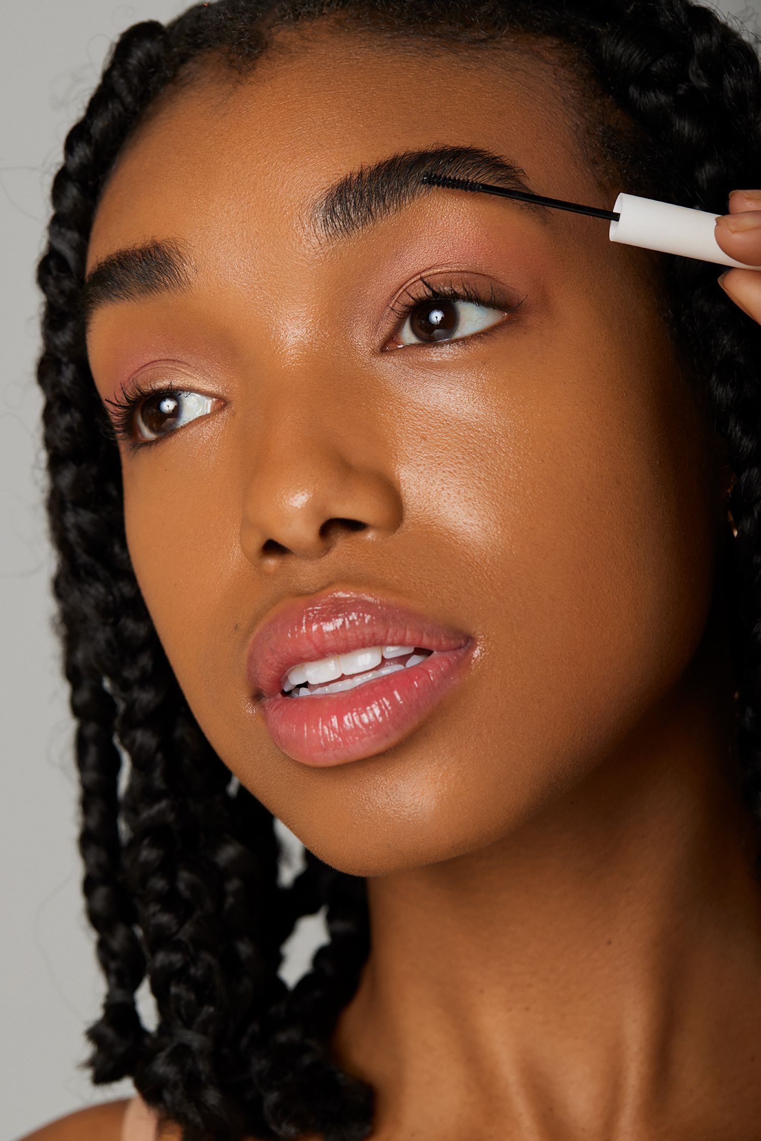 a woman is putting mascara on her eyebrows