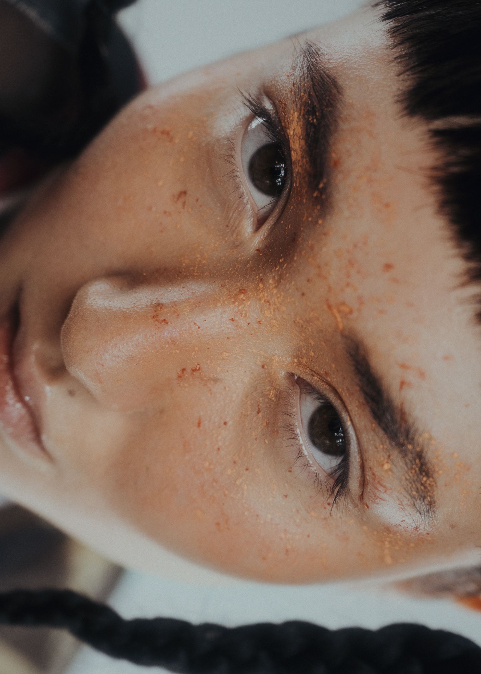 a close up of a woman with orange paint on her face