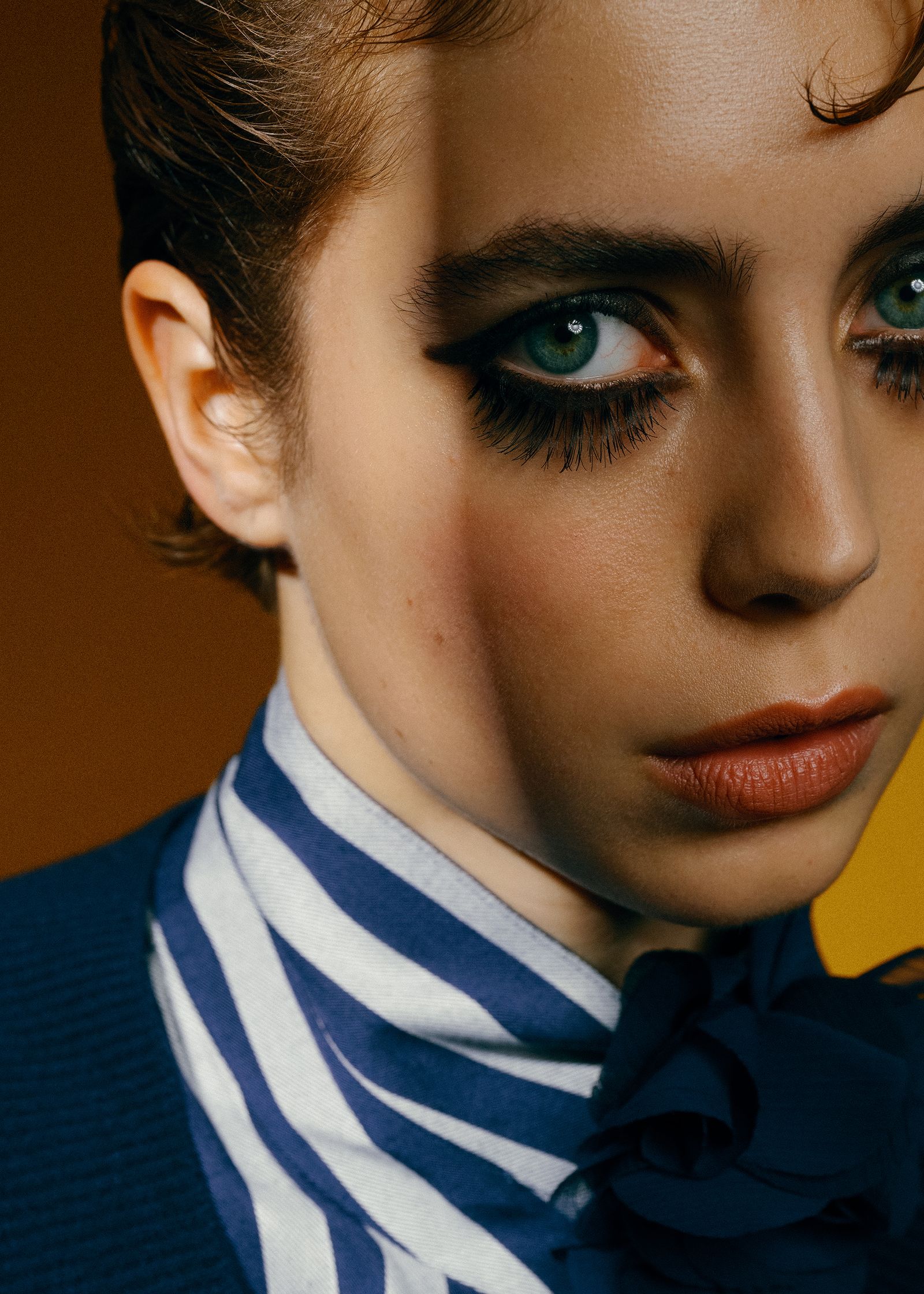 a woman wearing a blue sweater and striped tie