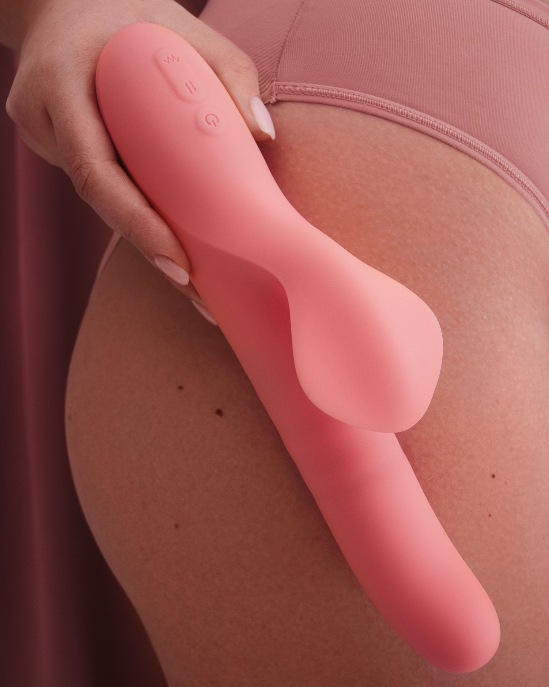 a woman is holding a pink sex toy