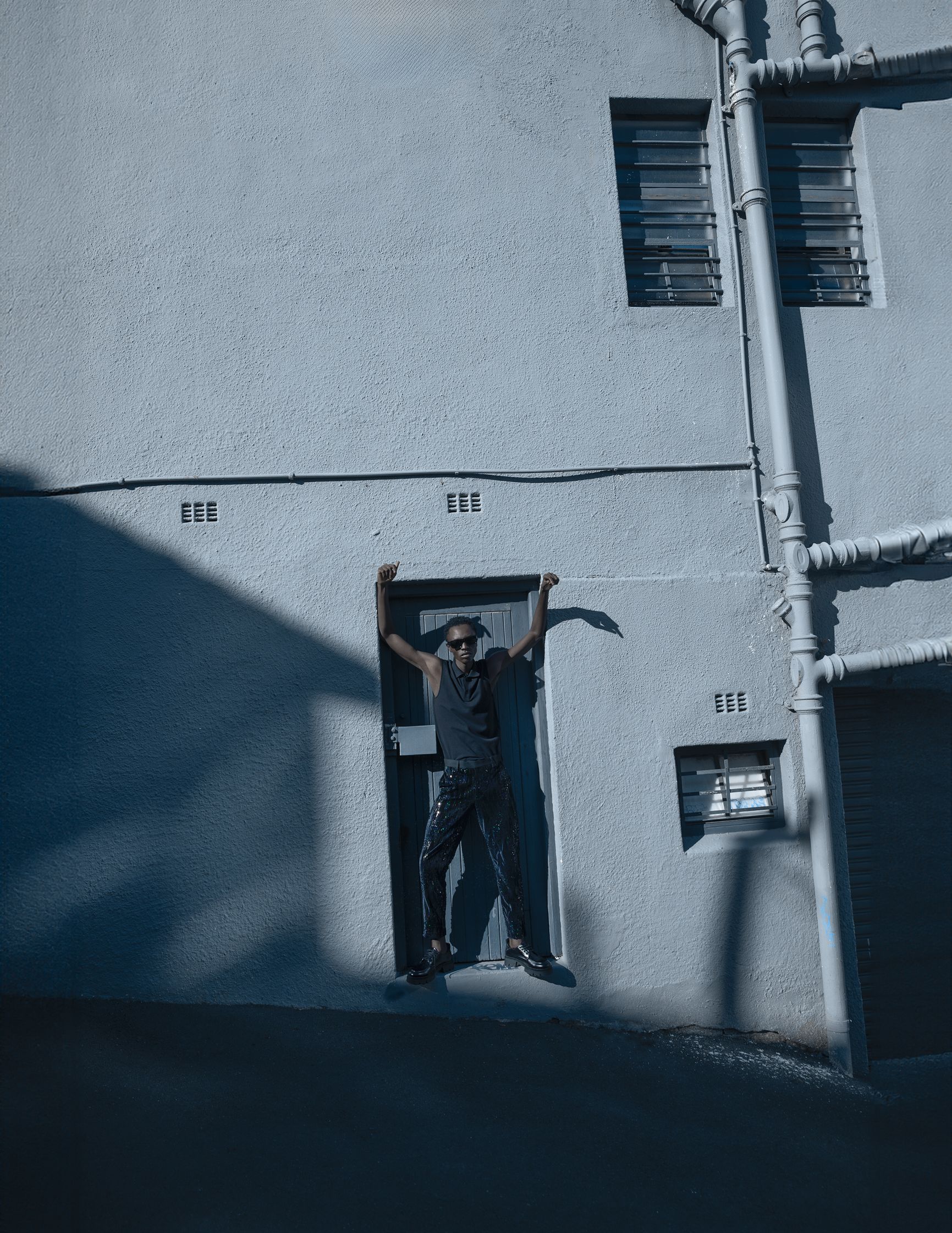a man on a skateboard leaning on the side of a building