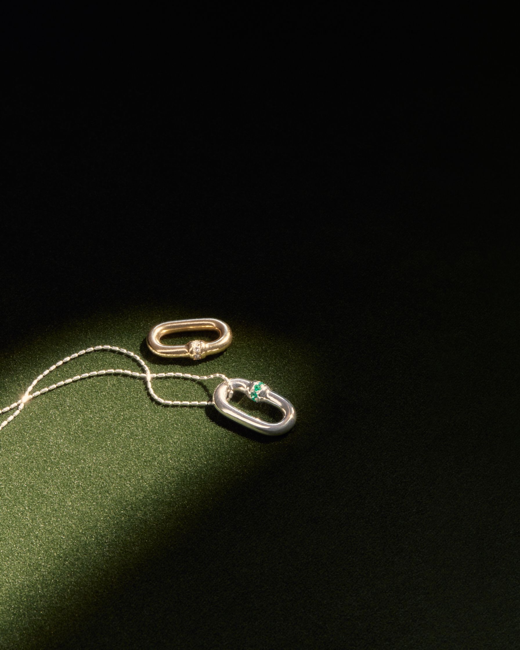 a pair of earrings and a necklace on a green surface