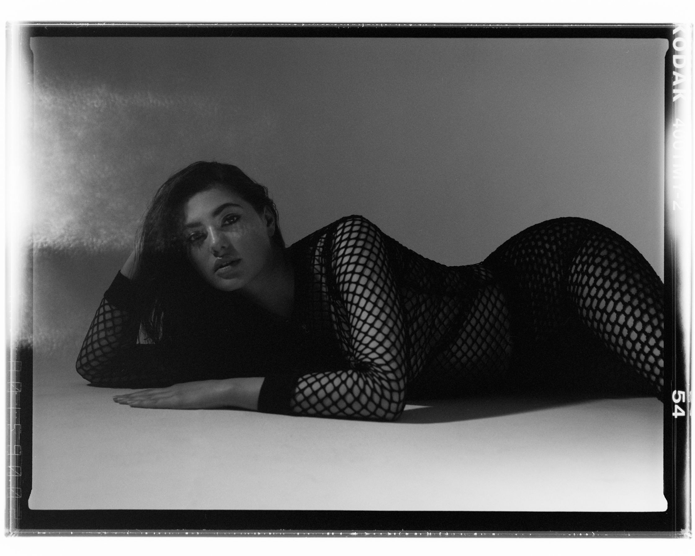 a black and white photo of a woman in fishnets
