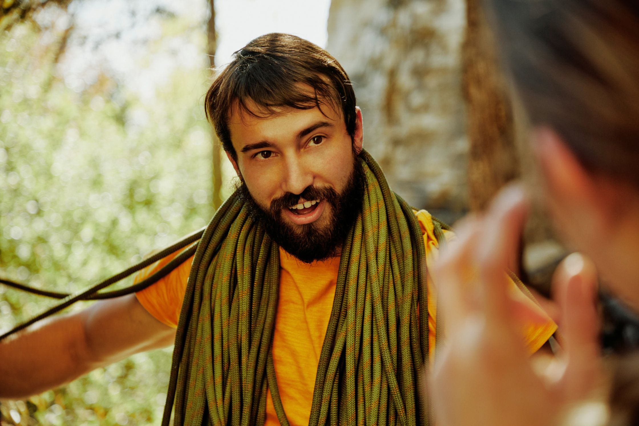 a man with a beard is talking to a woman in the woods