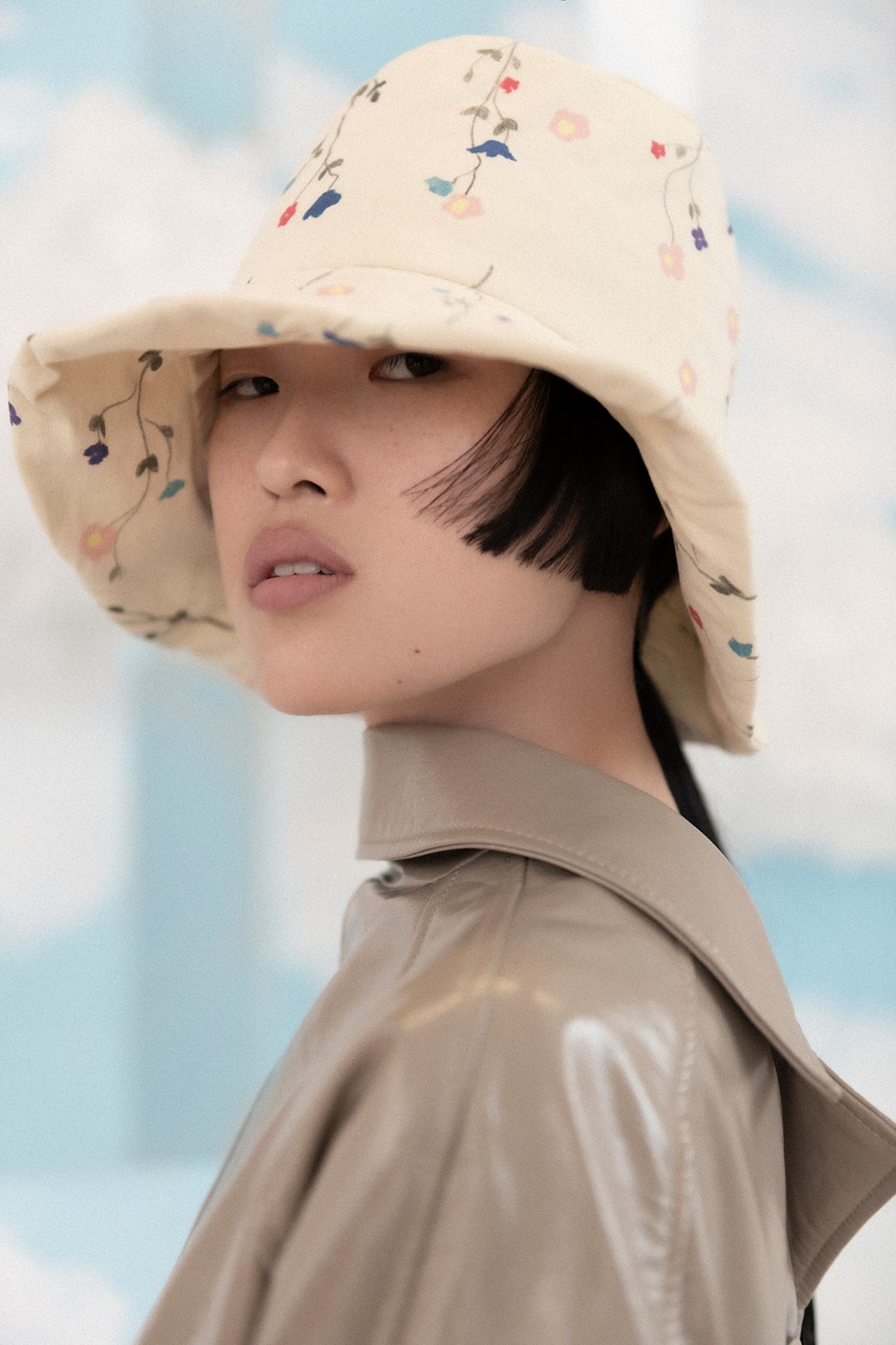a woman wearing a hat with flowers on it