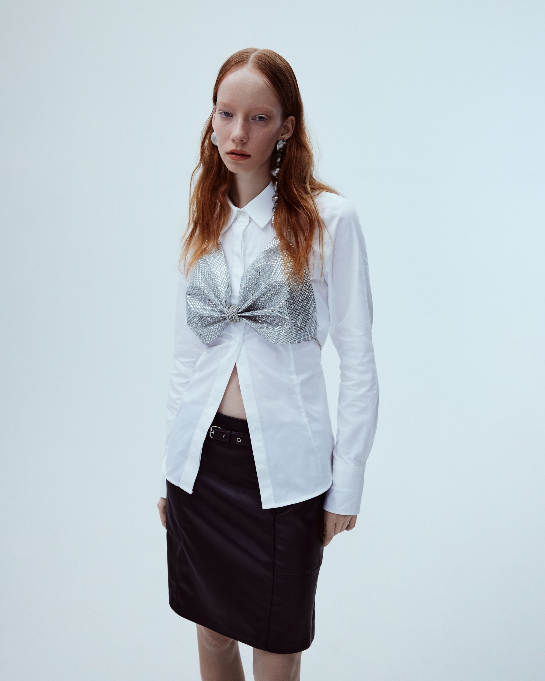 a woman in a white shirt and black skirt