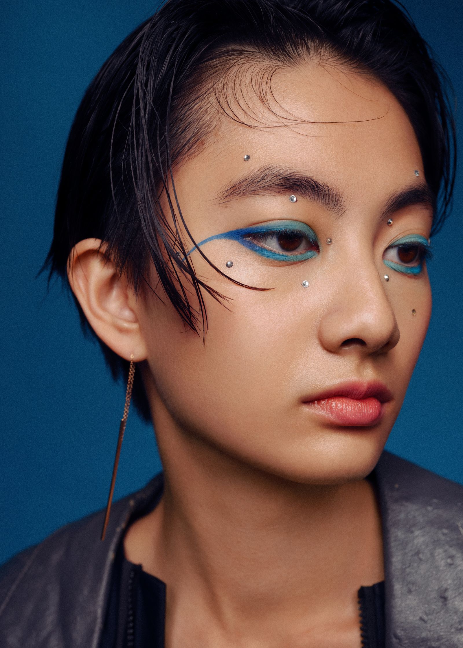 a woman with blue eye makeup and piercings
