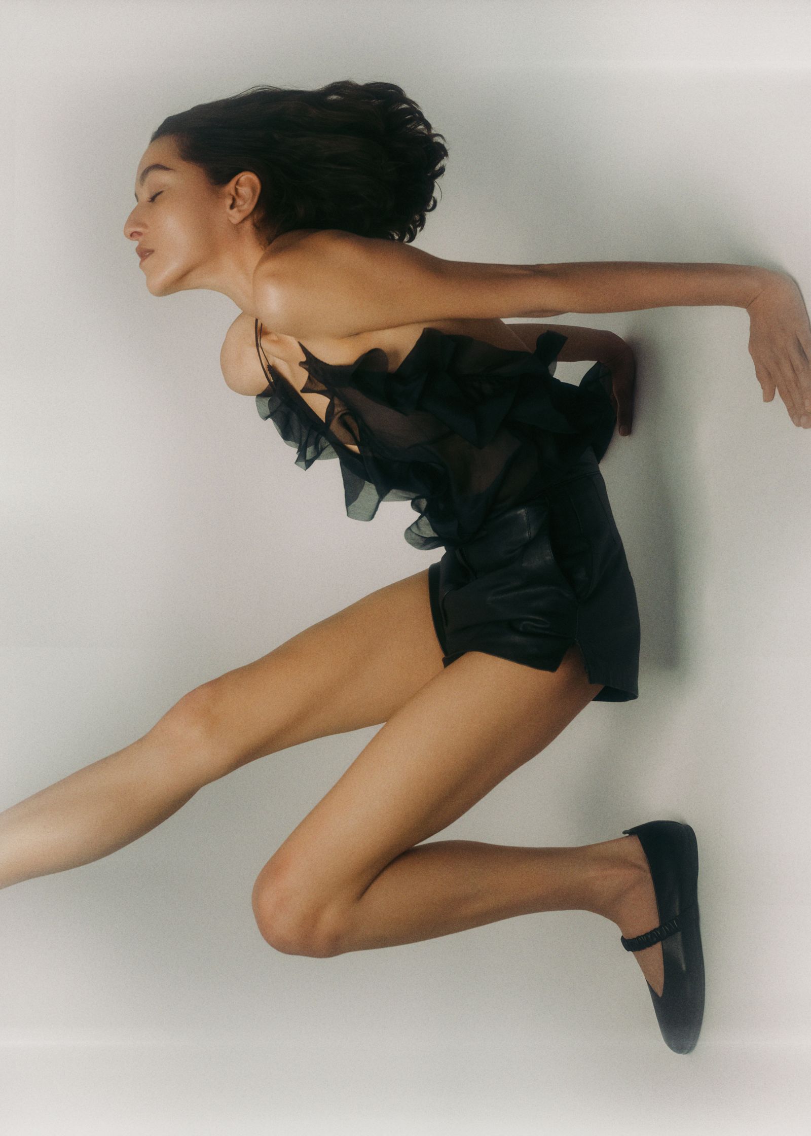 a woman in a black dress is jumping in the air