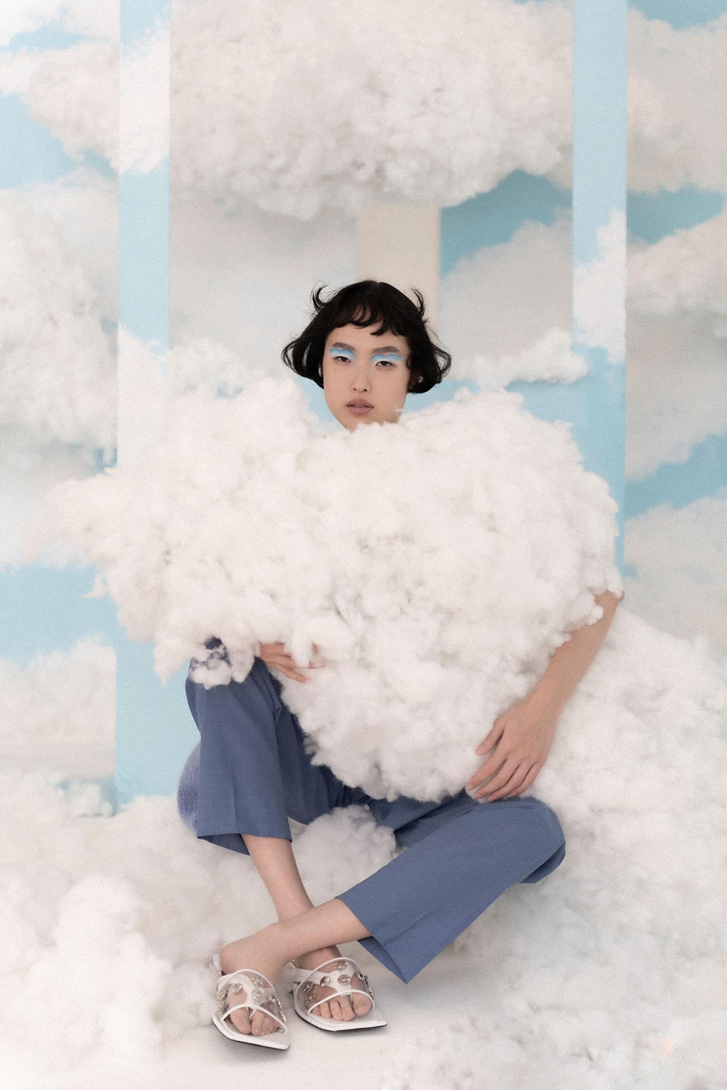 a woman sitting on top of a cloud