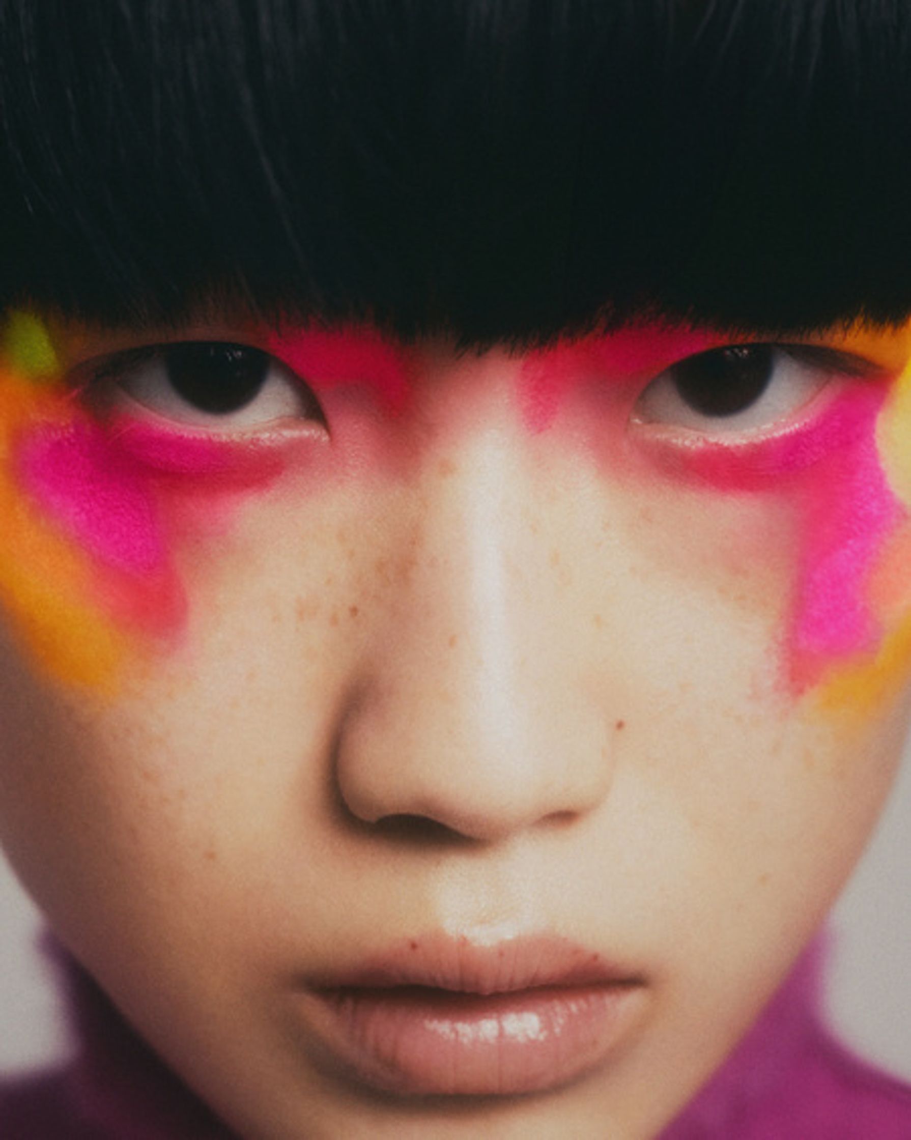 a young girl with colorful makeup on her face
